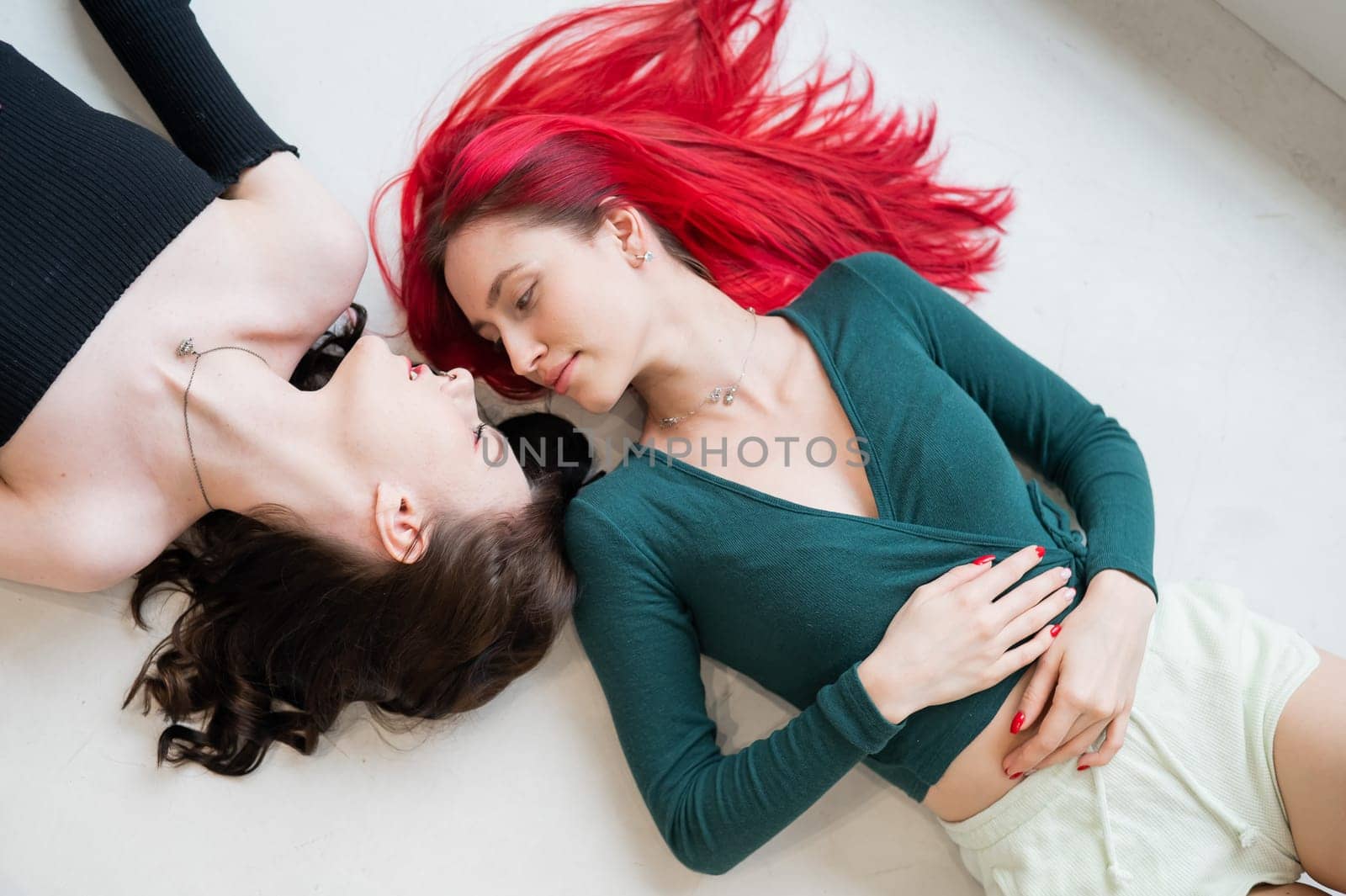 Top view of caucasian women lying and kissing