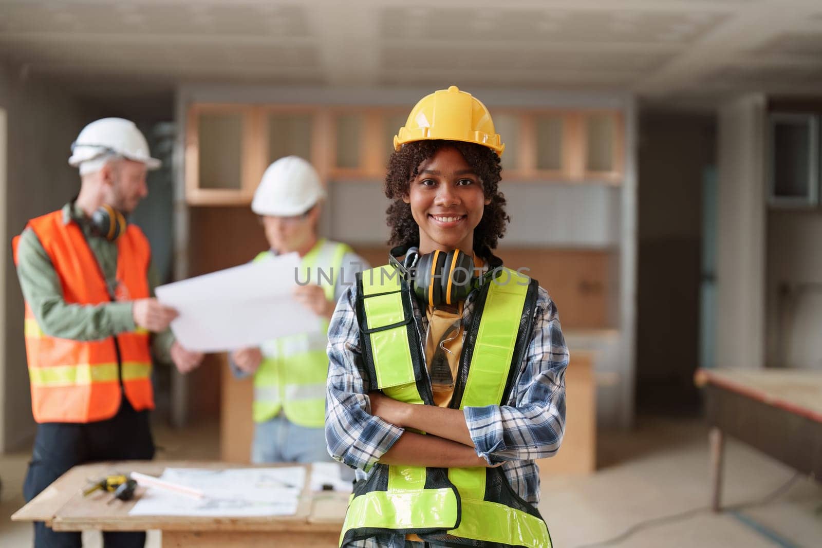 Foreman builder woman at construction site. American African foreman construction standing at construction site.
