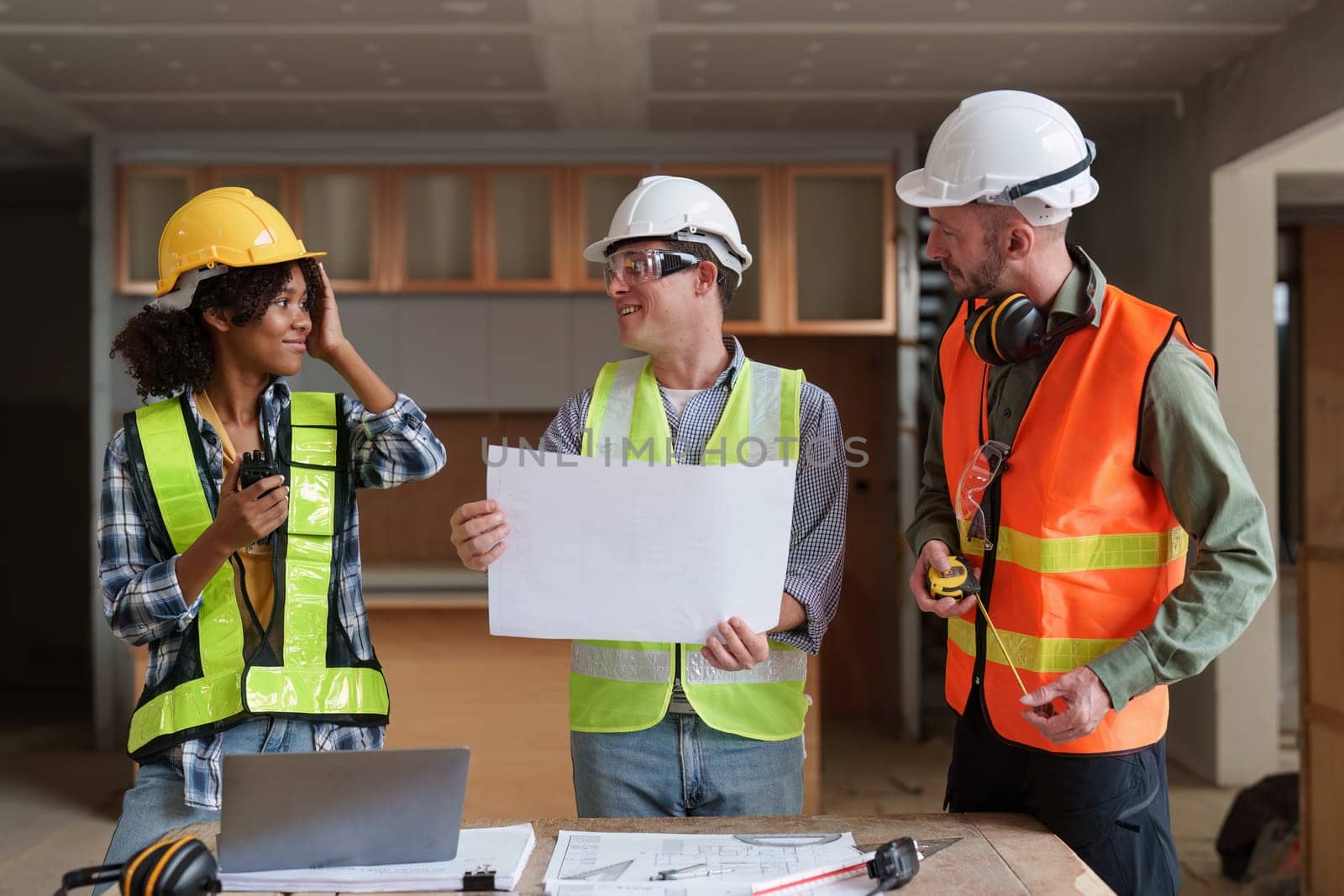 Architect team working with blueprints for architectural plan, engineer sketching a construction project, green energy concept.