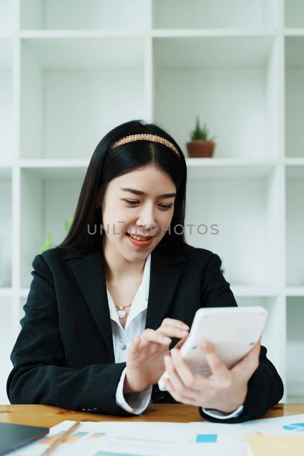 financial, Planning, Marketing and Accounting, portrait of Asian employee checking financial statements using documents and calculators at work by Manastrong