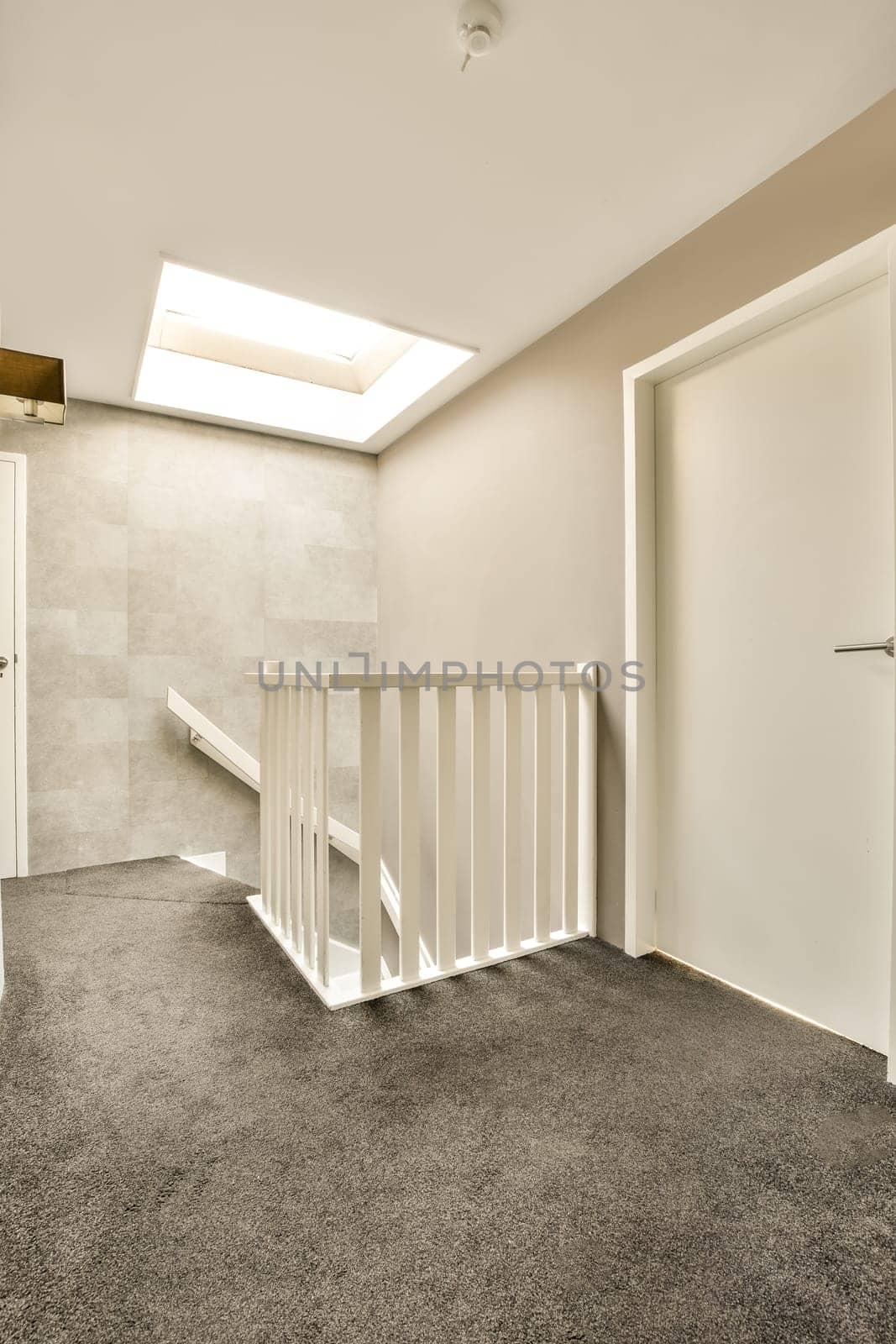 a room with a staircase and a door to a by casamedia