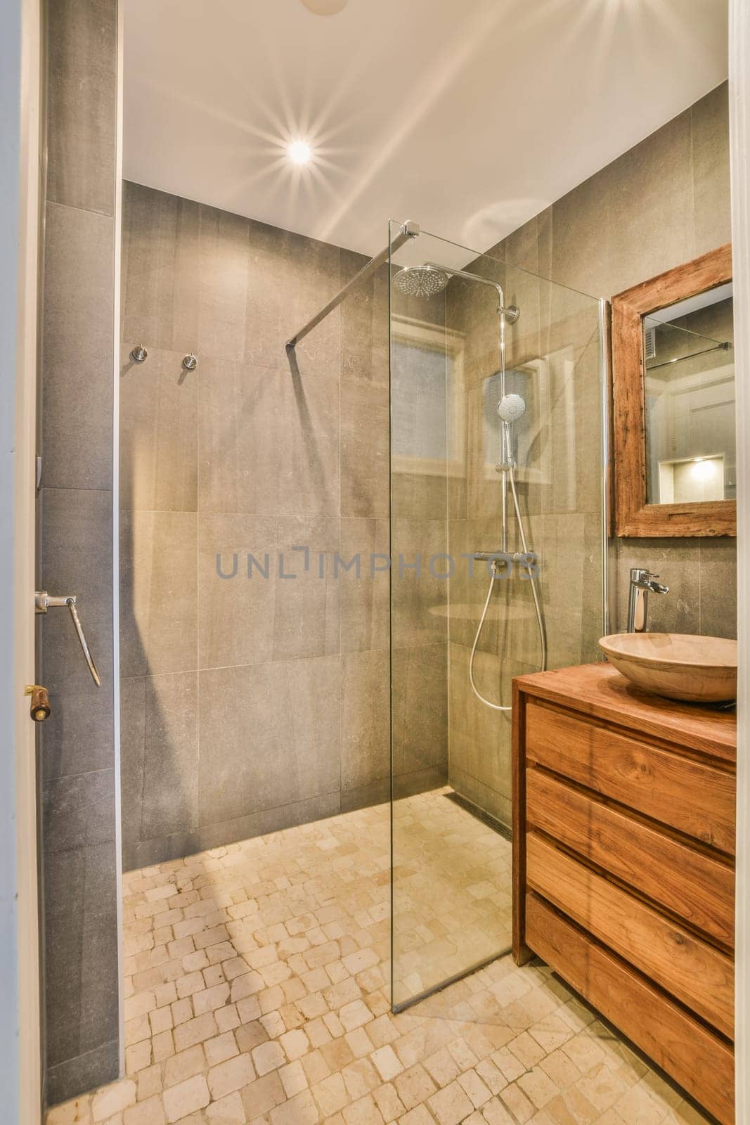 a bathroom with a wooden vanity and glass shower stall in the corner on the left is a large walk - in shower