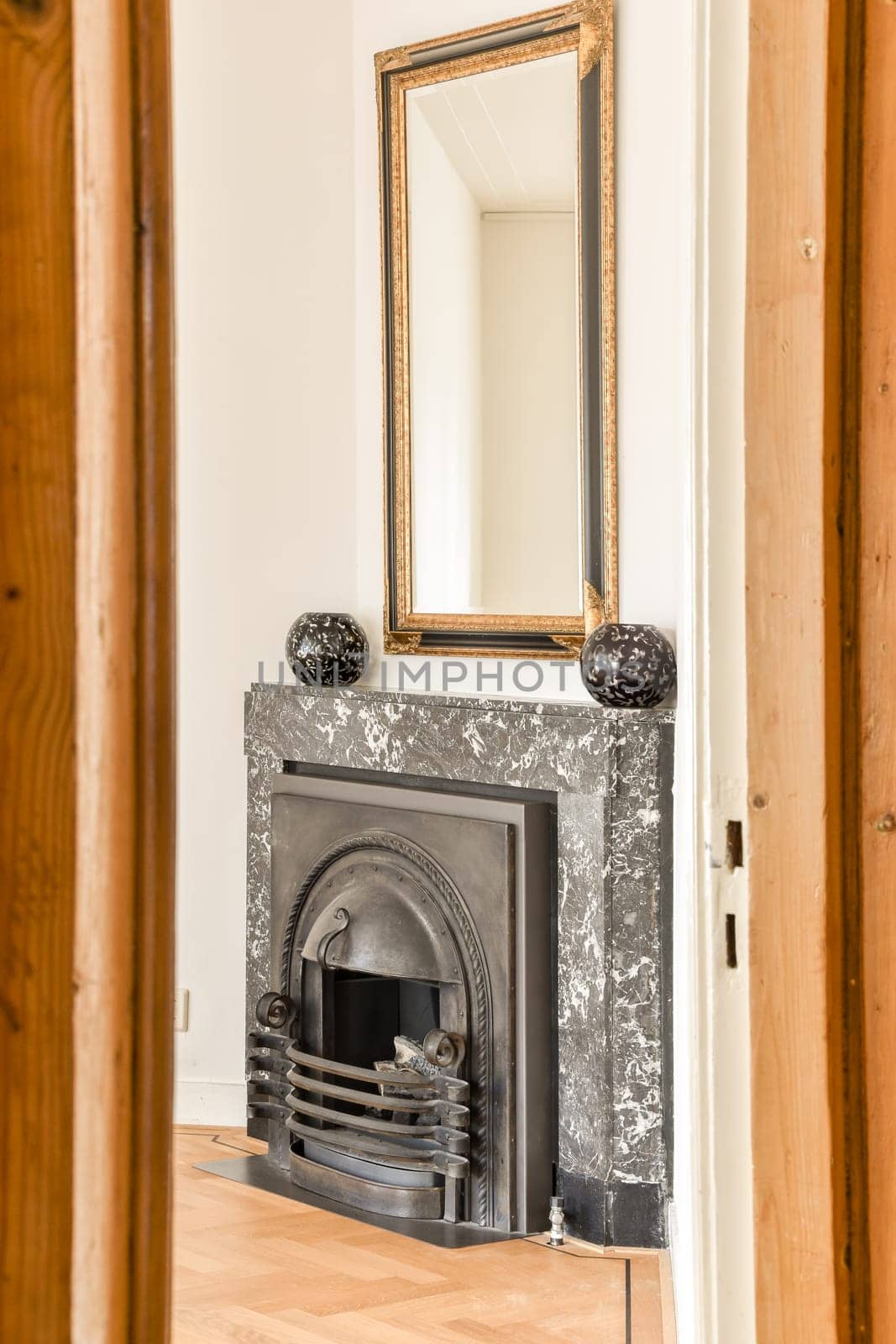 a fireplace in a room with wood paneling and a mirror on the wall above it that has been painted white