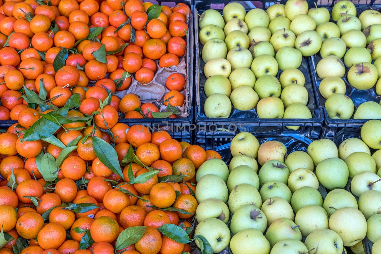 Green apples and tangerines for sale at a market