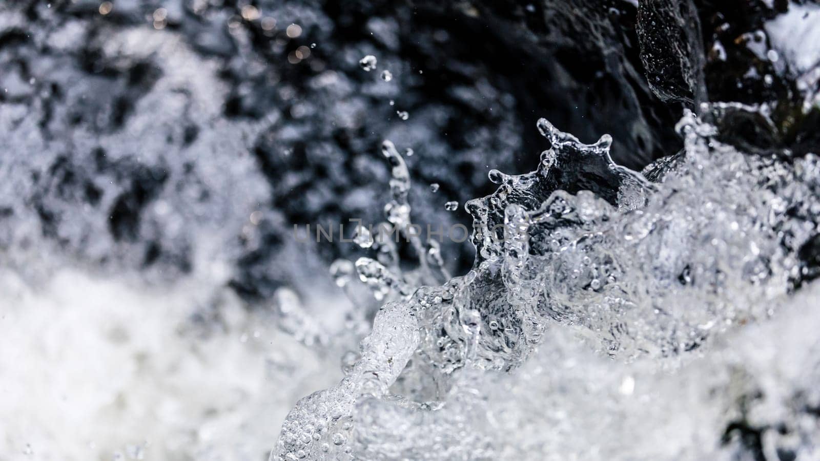 Close focus on body of splashing water of fast flowing stream in river.