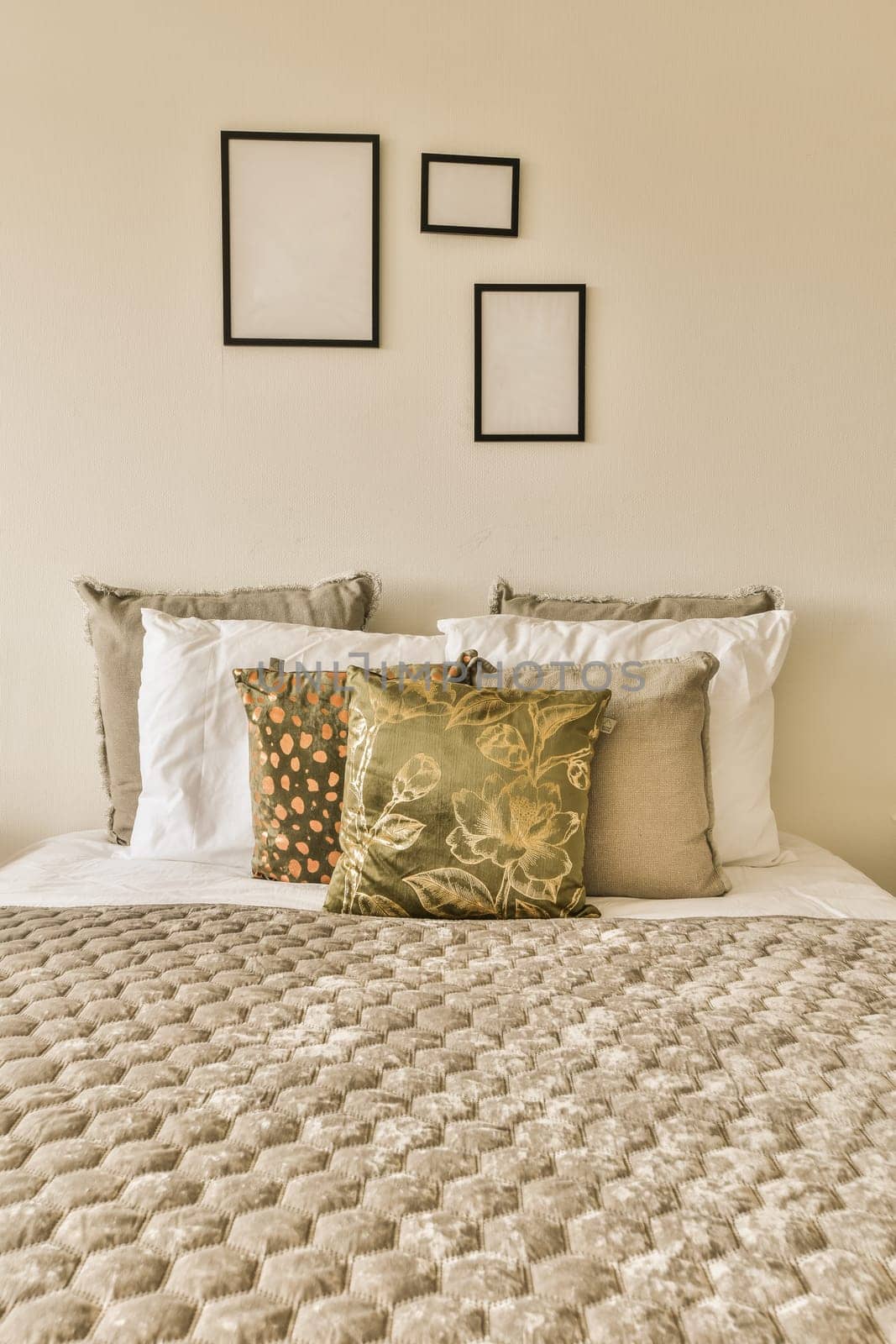 a bed with pillows and pictures on the wall by casamedia