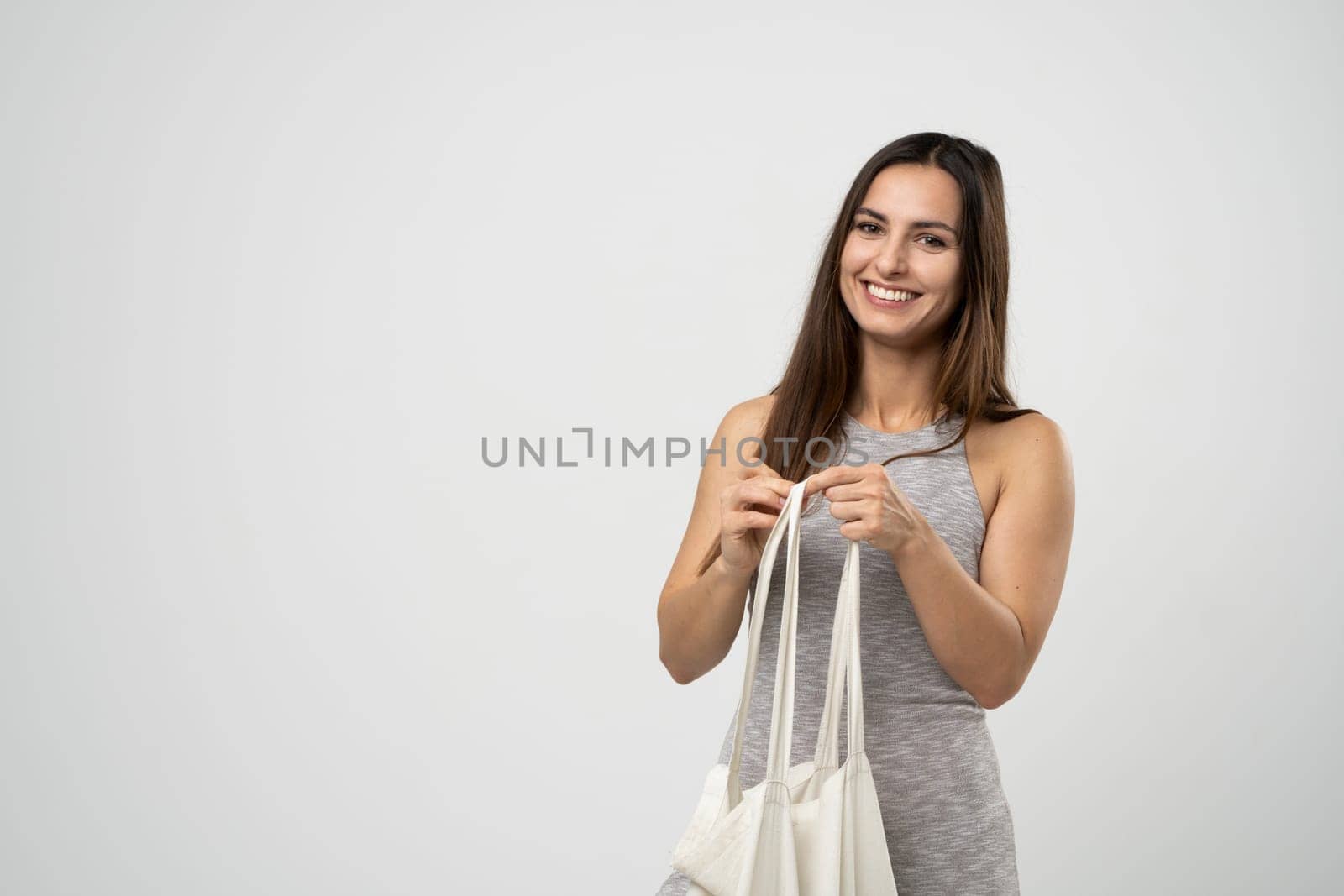 Ecology Concept. Woman holding cotton grocery bag with vegetables. Reusable eco bag for shopping. Zero waste concept. Eco friendly lifestyle. Isolated white background. by vovsht