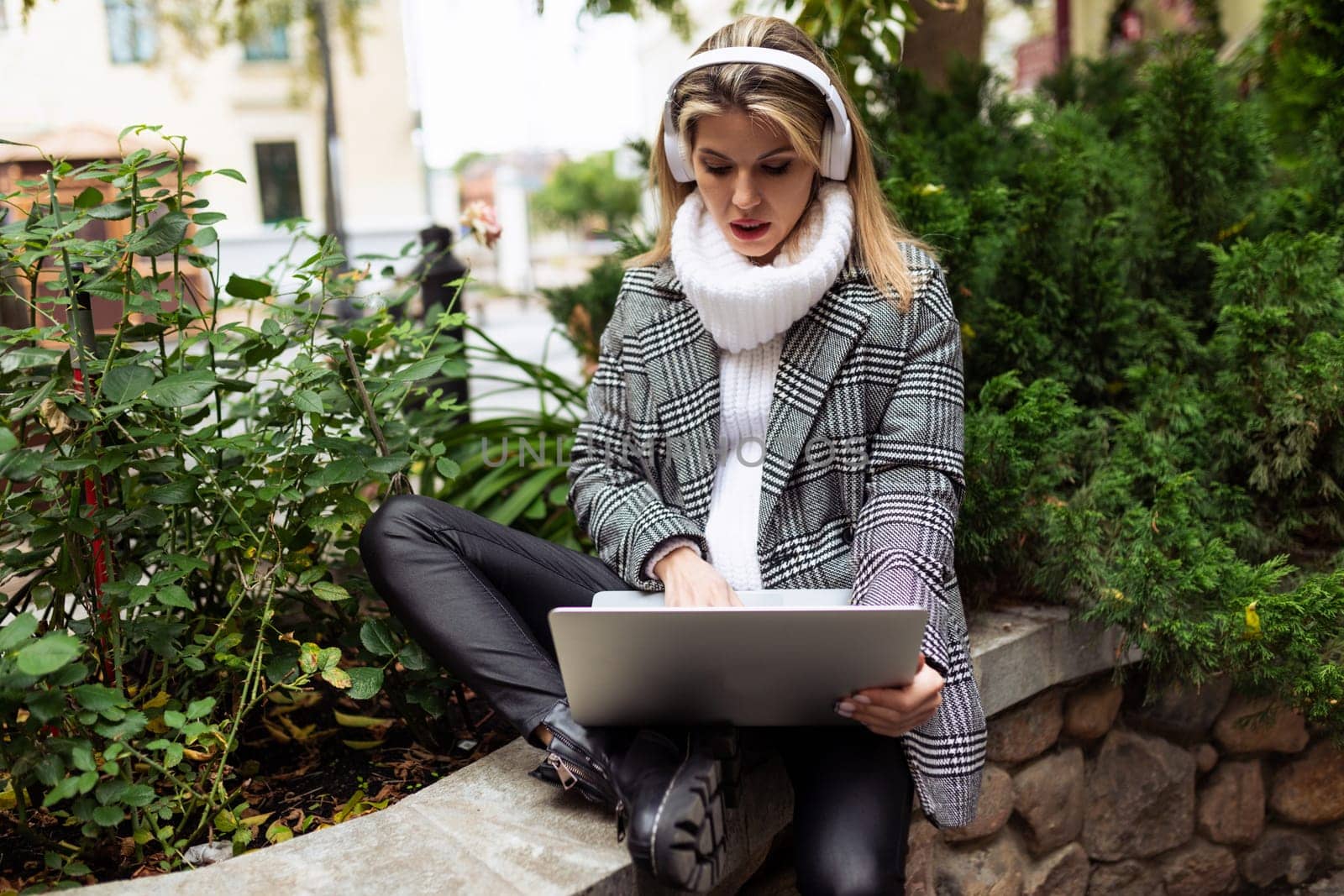 a woman tourist with headphones and a laptop studies the route of the city by TRMK