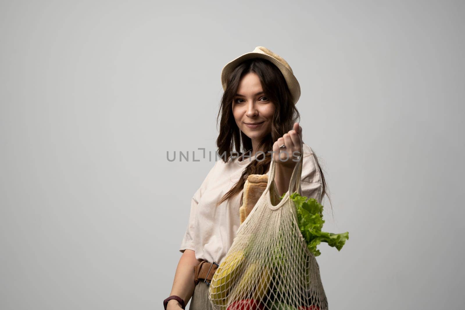 Attractive beautiful happy woman carries cotton bag full of organic vegetables and fruits. Zero waste concept, sustainable lifestyle, eco friendly concept, no plastic. by vovsht