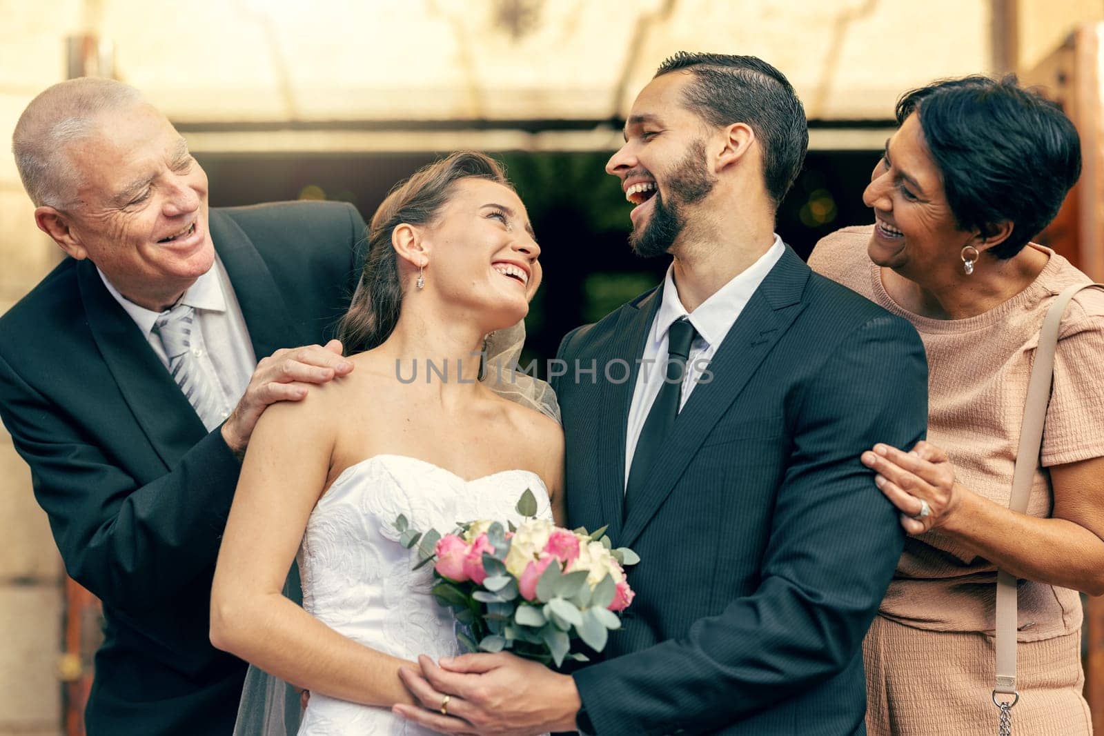 Wedding, happy and couple with parents at a celebration of love at an event with happiness. Smile, celebrate and young bride and groom after marriage with mother and father together at a church by YuriArcurs