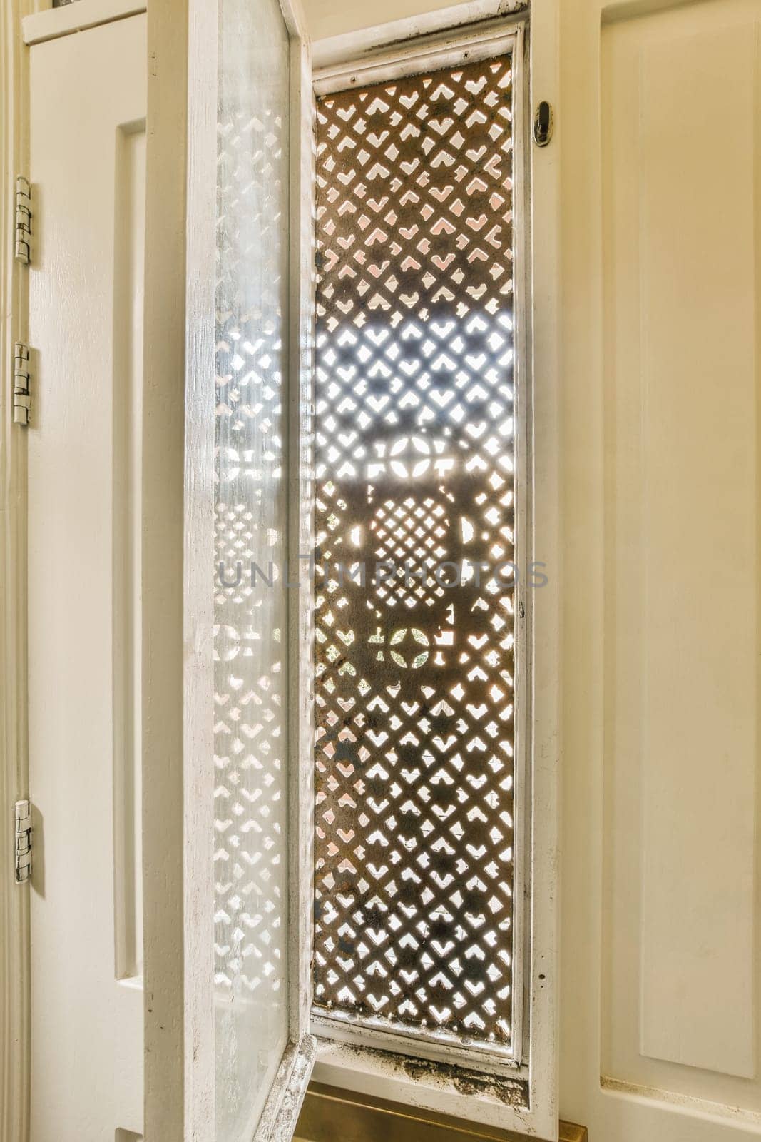 a window in a door with a lattice pattern by casamedia