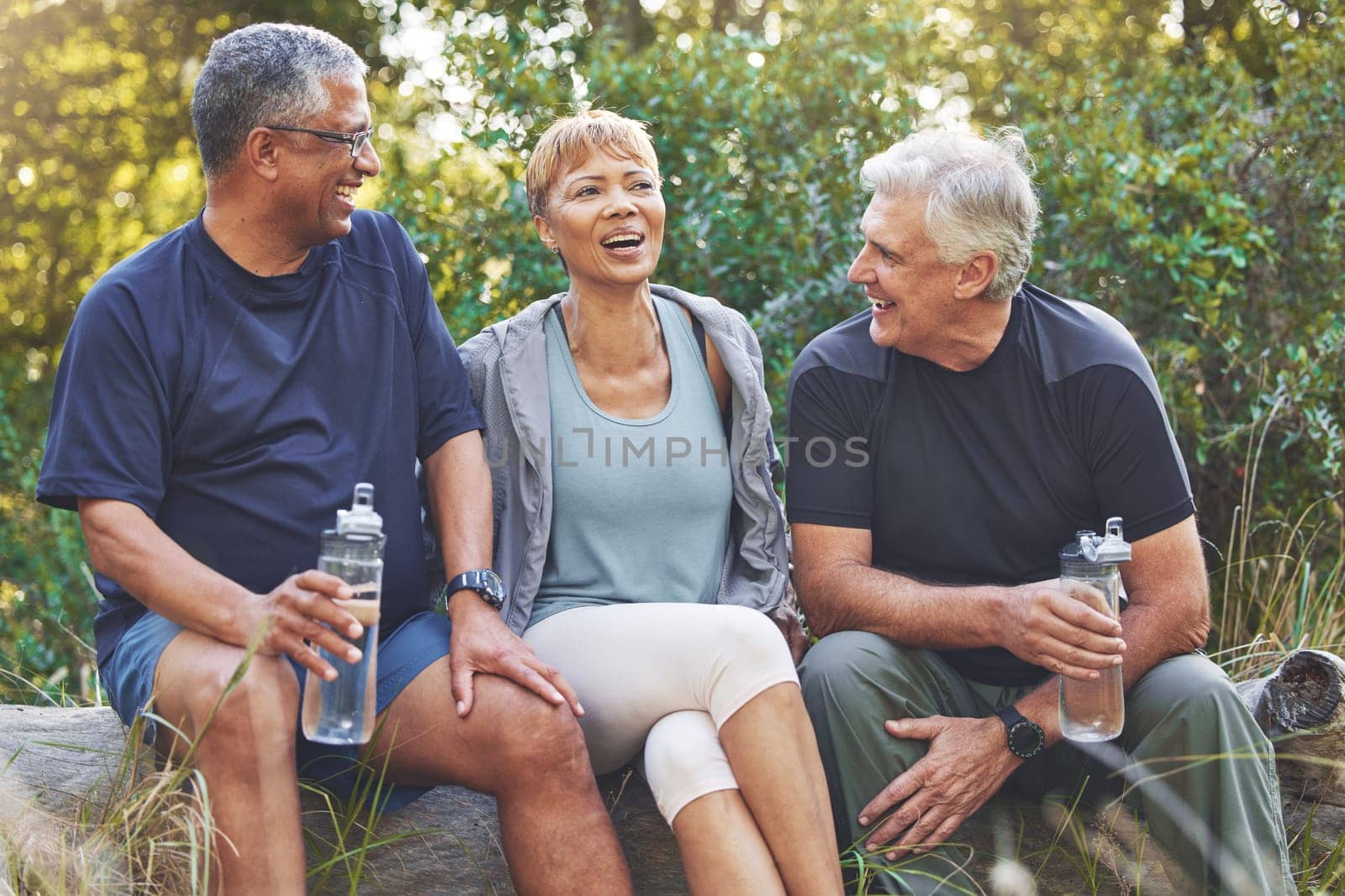 Nature, fitness and senior friends in conversation while sitting in the forest after hiking. Happiness, communication and elderly people talking, bonding and drinking water after outdoor exercise. by YuriArcurs