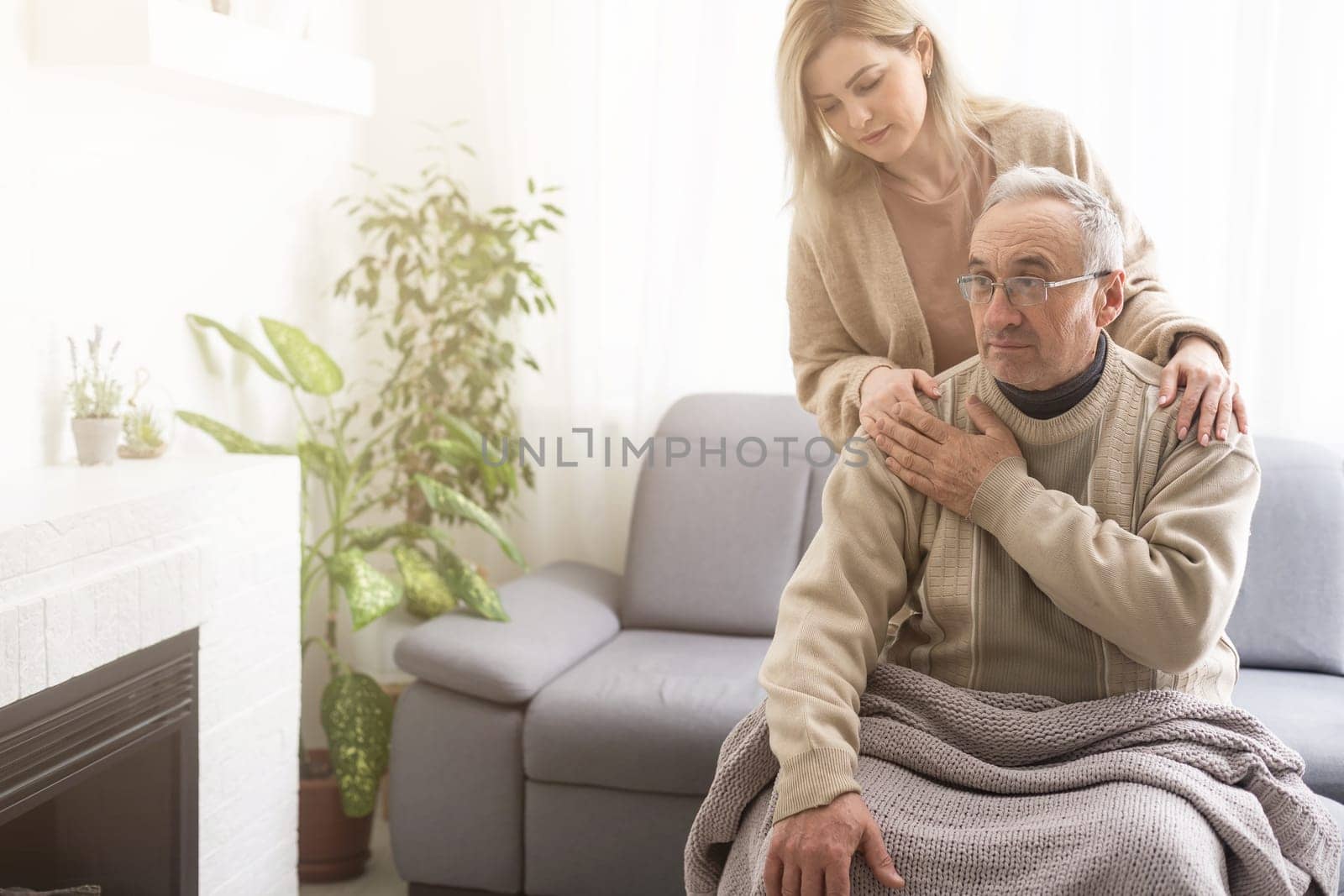 Nurse holding hand of senior man in rest home.