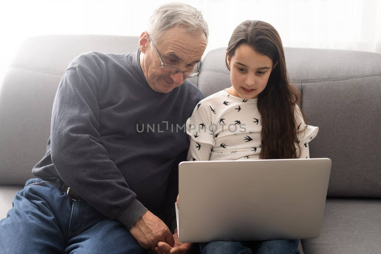 grandfather and granddaughter with laptop by Andelov13
