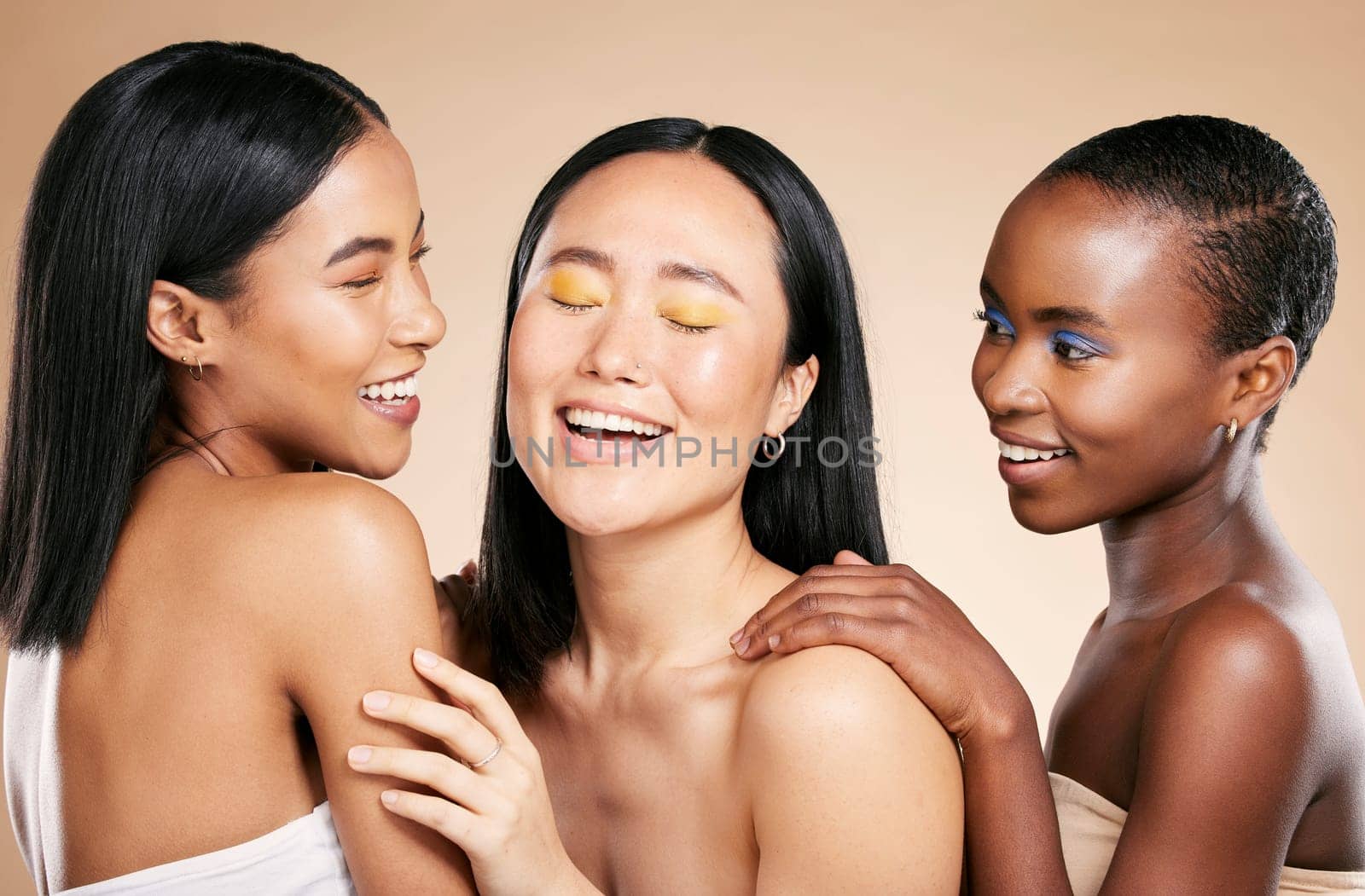 Happy, friends and beauty in studio for wellness, hygiene and creative grooming on brown background. Smile, women and eyeshadow by girl with different, skin and luxury skincare, relax and isolated.
