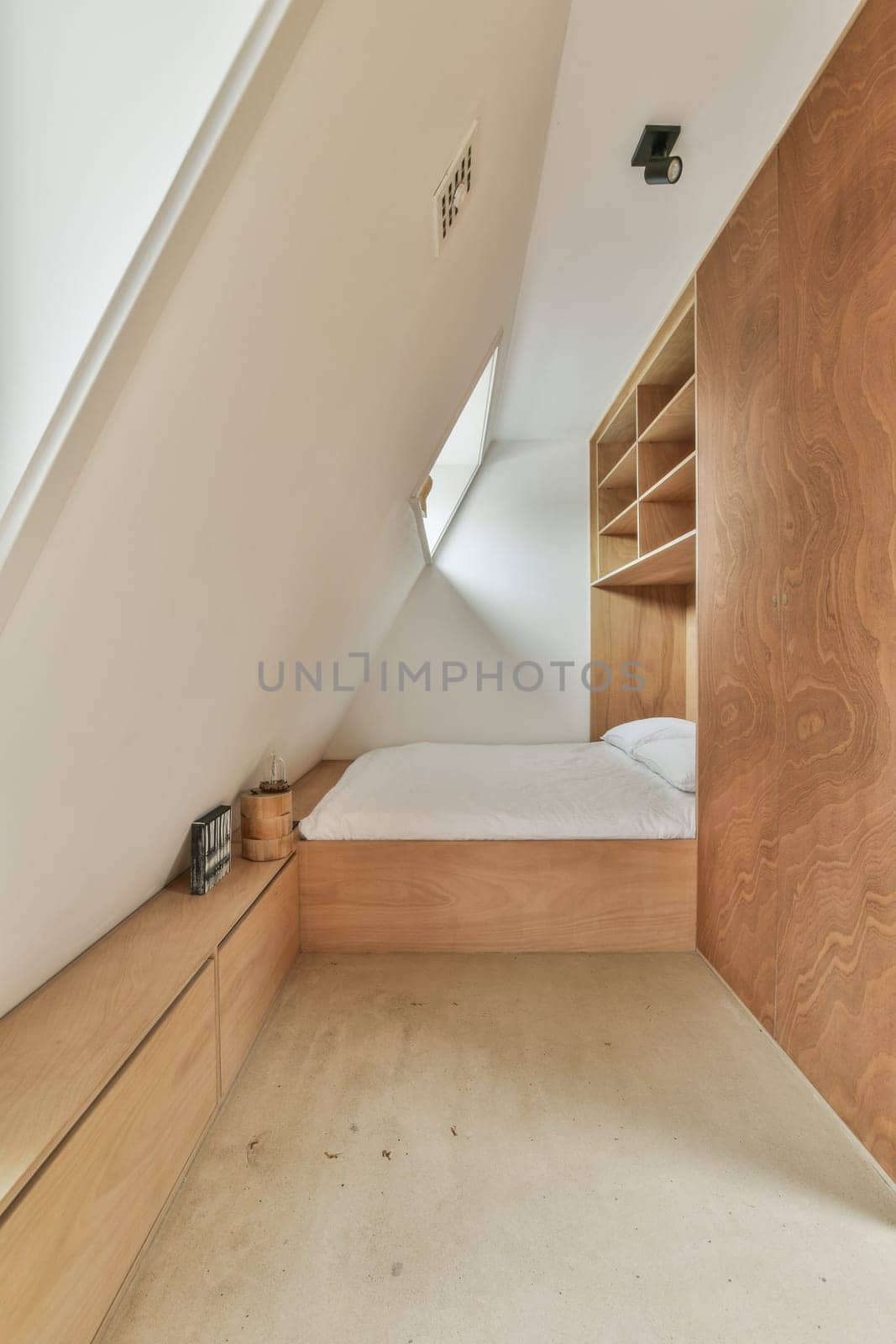 a small bedroom with a bed and a wooden cabinet by casamedia