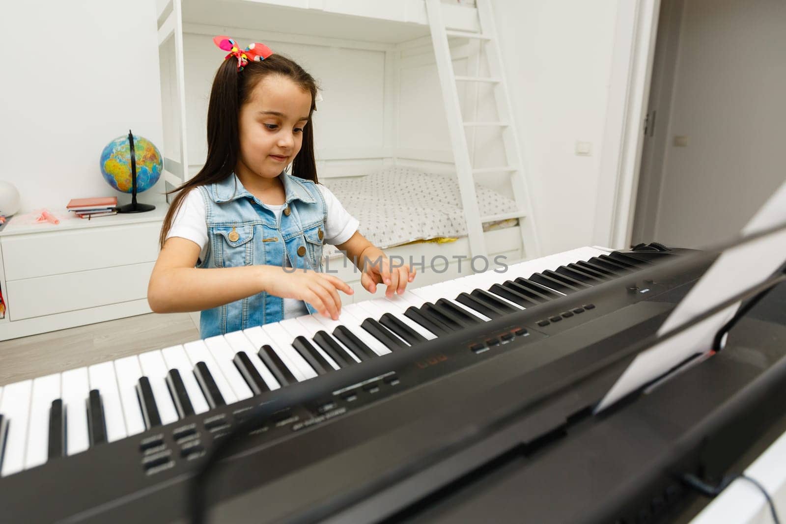 a cute little girl learning to play the synthesizer. by Andelov13