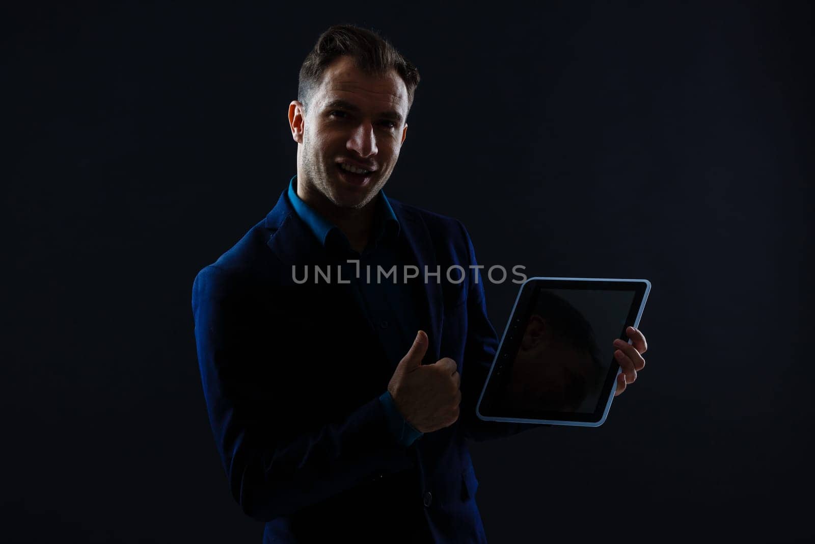 business, people and future technology concept - close up of businessman with tablet pc computer over black by Andelov13