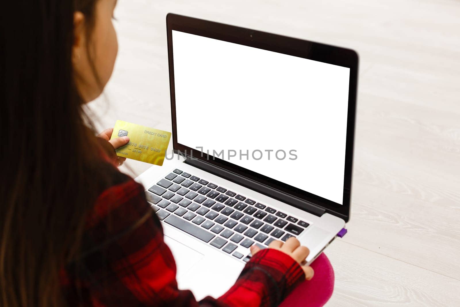 Little girl Hands holding credit card and using laptop.Online shopping in childhood. by Andelov13