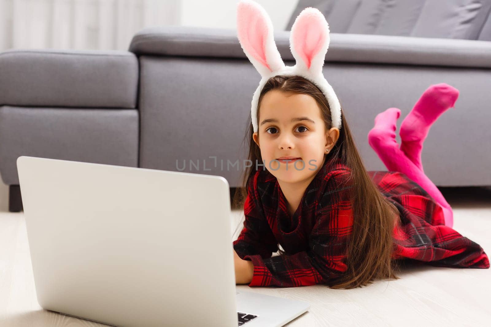 Little girl with her bunny using computer together preparing for easter- by Andelov13