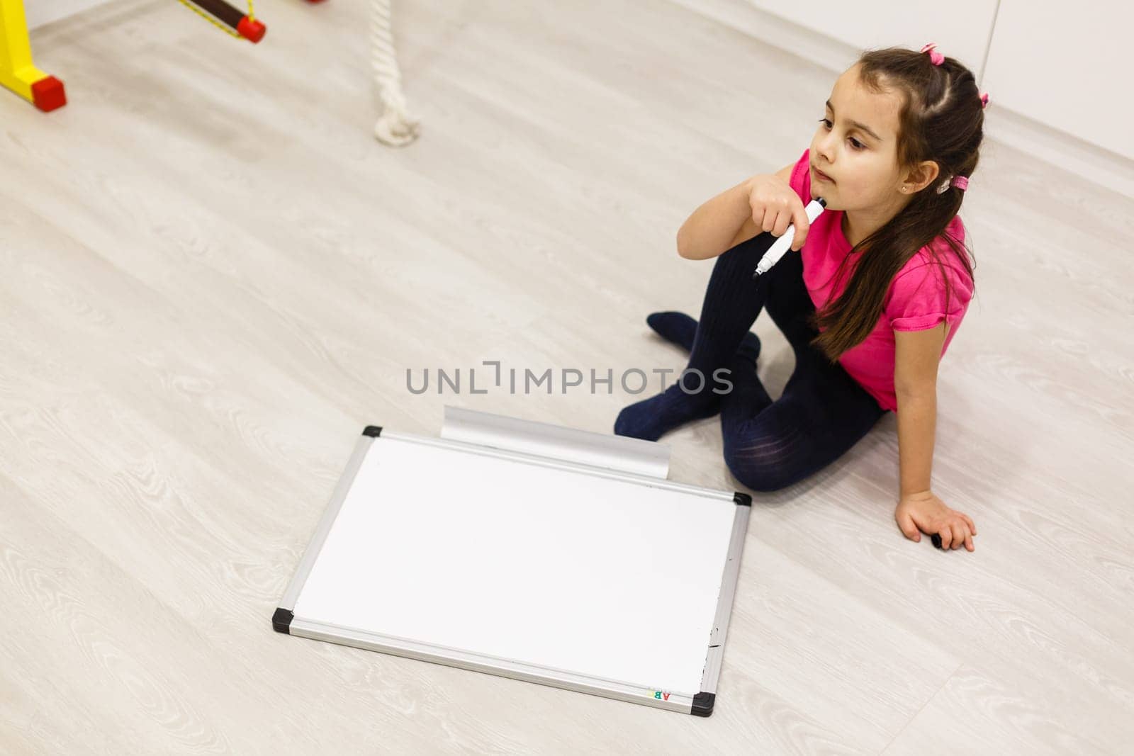 little girl writing on the white board, schooling background.