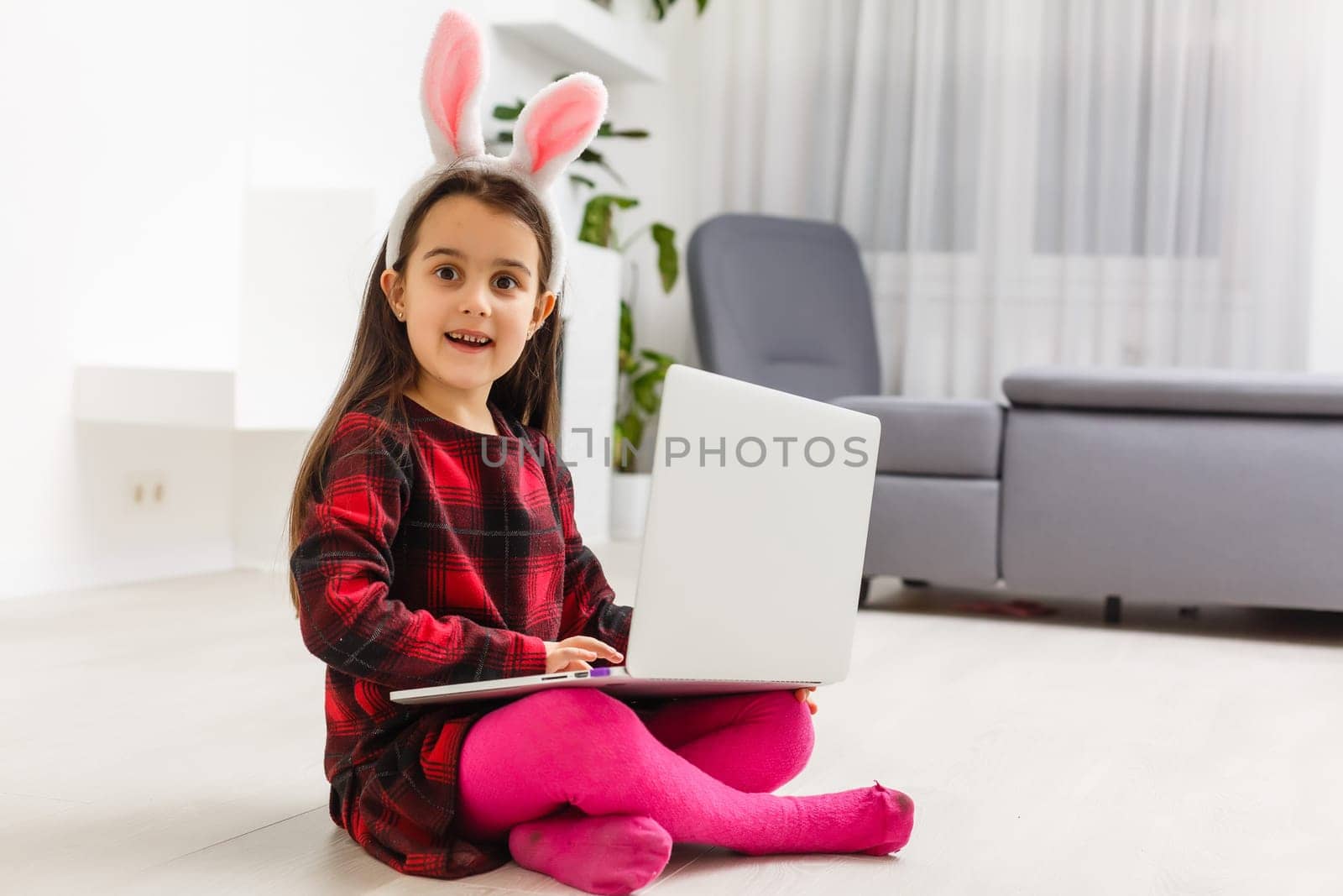 Little girl with her bunny using computer together preparing for easter-shallow depth of field by Andelov13