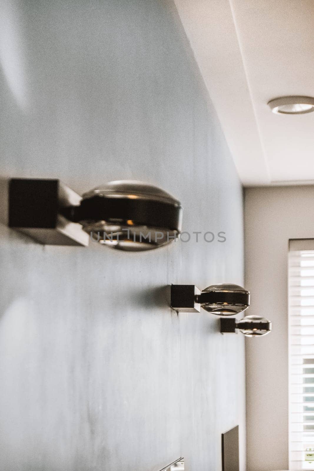 some lights on the side of a wall in a room that has been painted blue and white with black trim