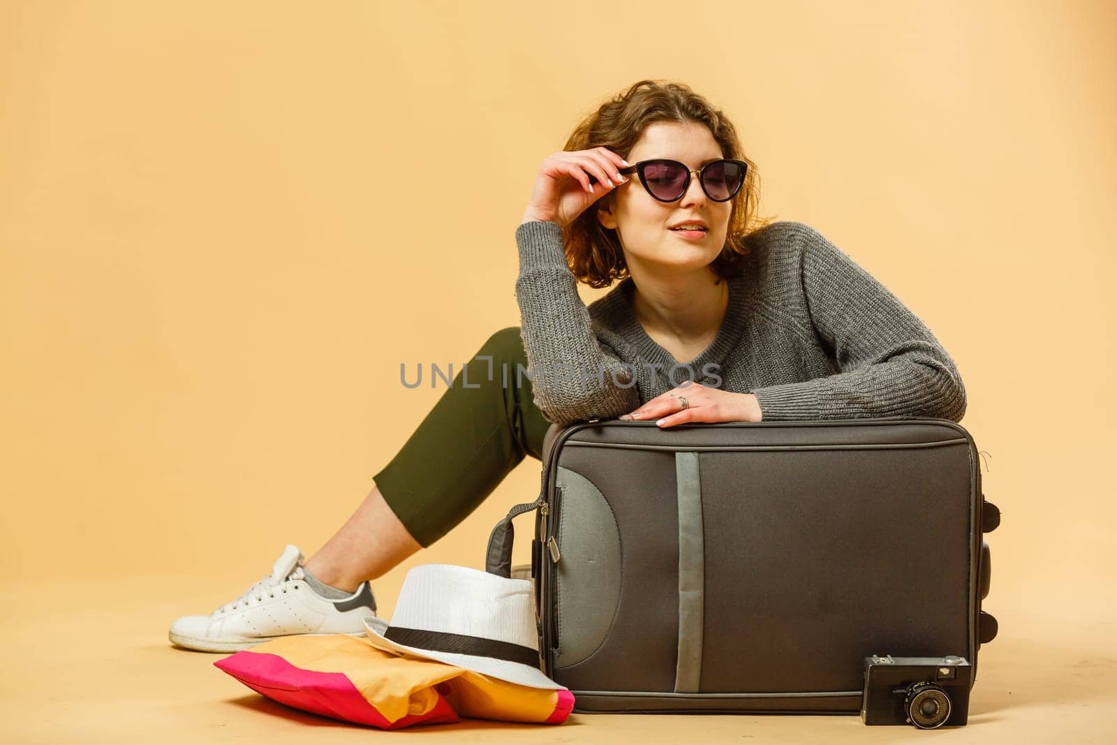 concept of travel. happy woman girl with suitcase and passport on yellow colored background