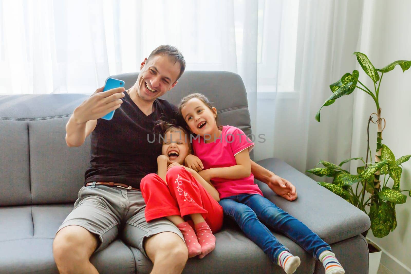 Young father with his cute little daughters taking selfie by Andelov13