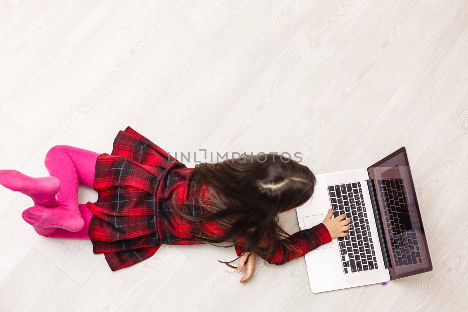 Top view of cute young girl using laptop by Andelov13
