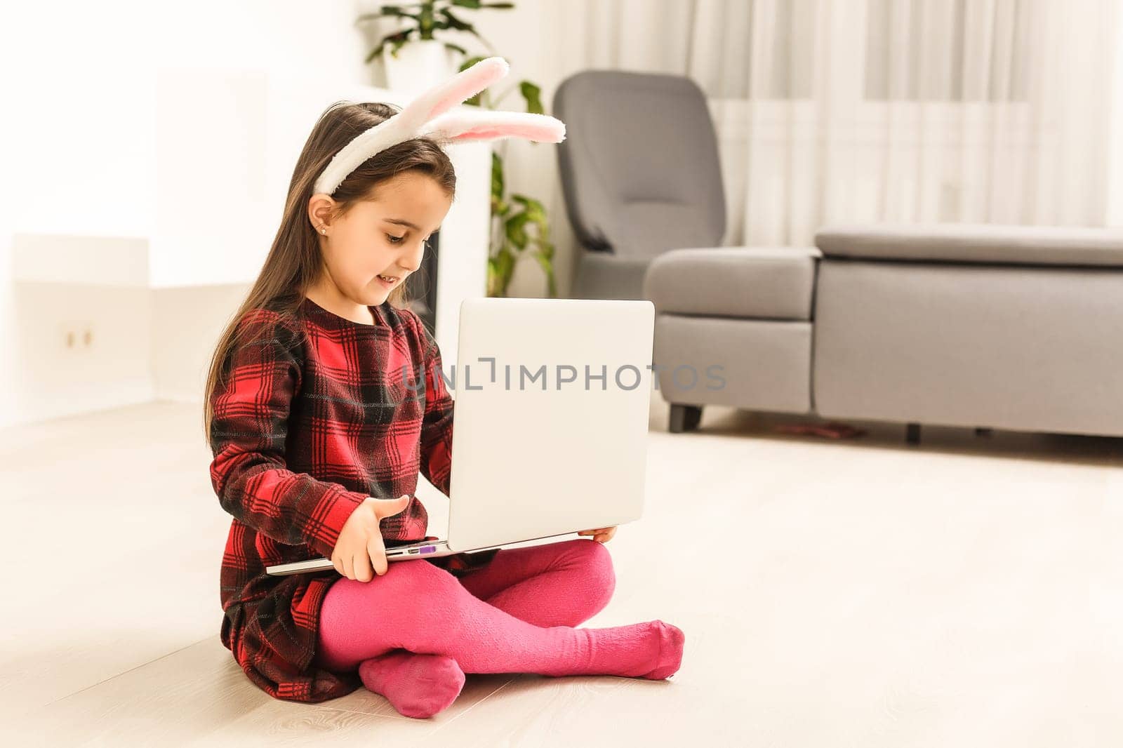 Little girl with her bunny using computer together preparing for easter-shallow depth of field