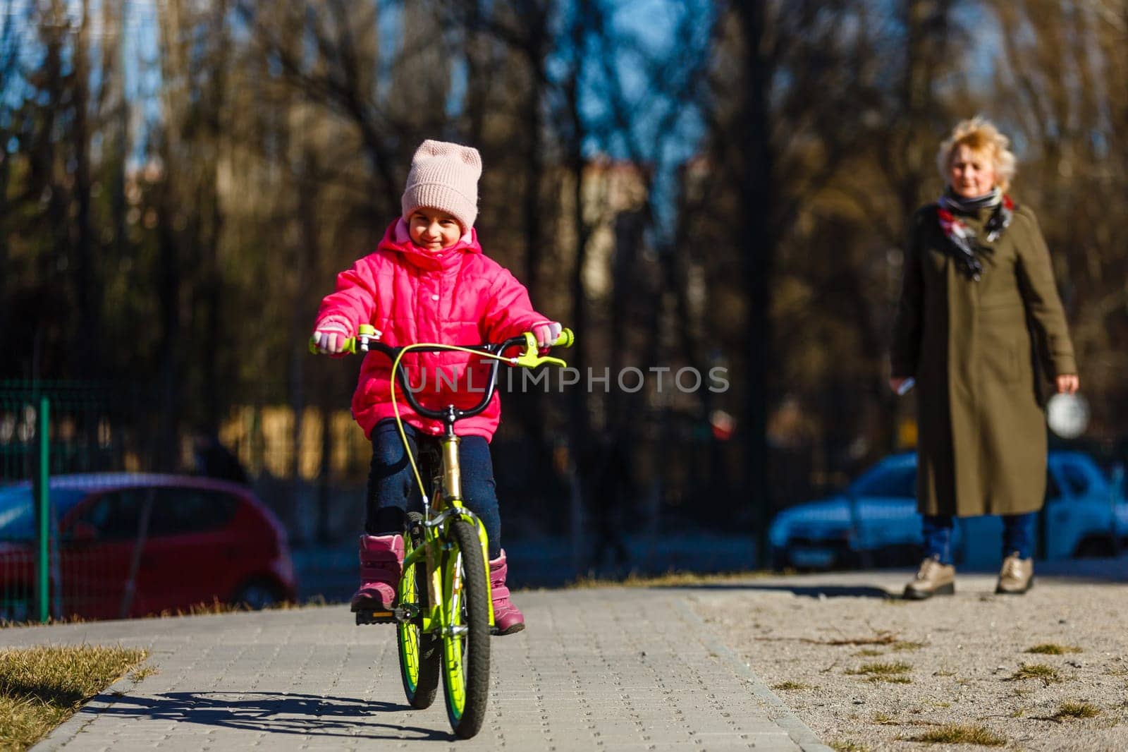 little girl riding bicycle in city park