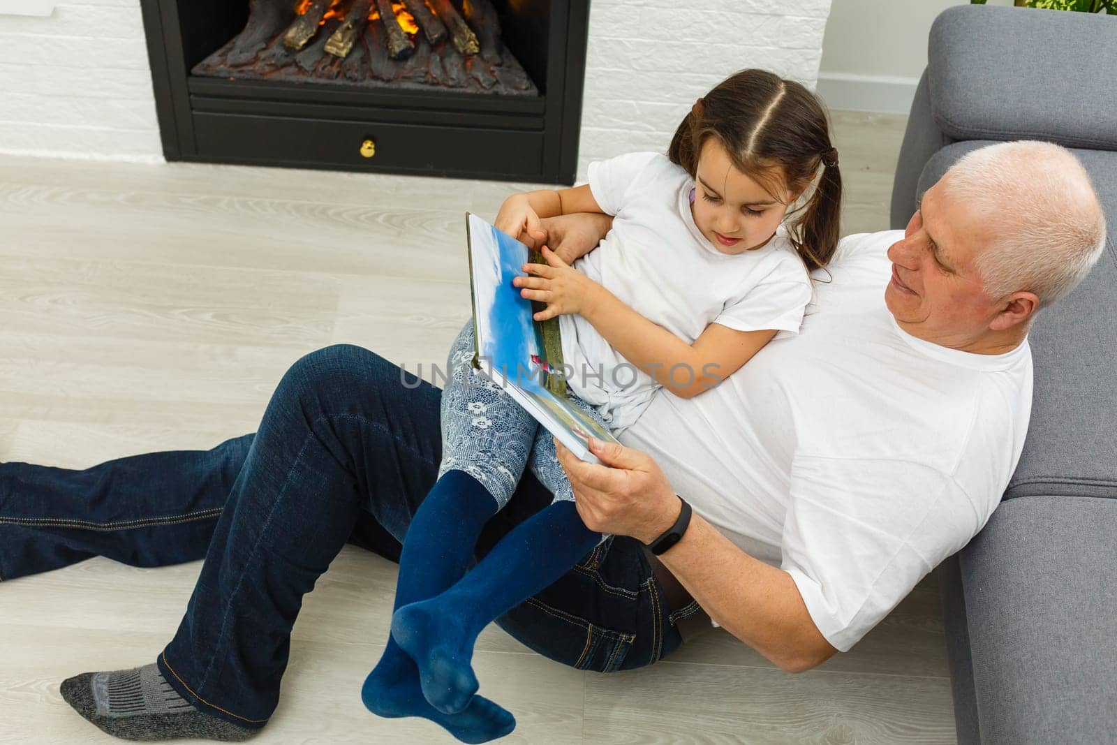 Senior man showing photos to his granddaughter.