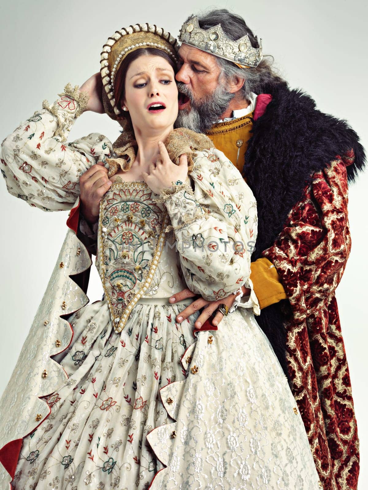 Medieval king, queen and violence in studio for drama, danger and together with renaissance clothes. Ancient royal couple, surprise and shock with distress, crying and actor with vintage fashion.