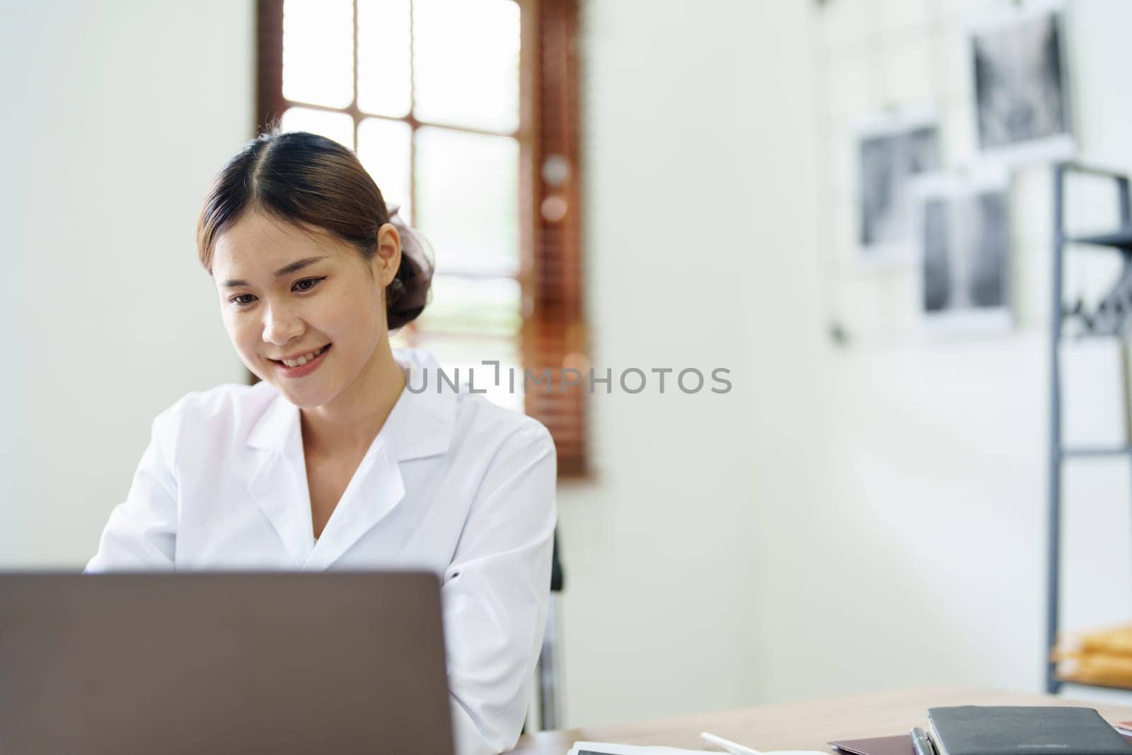 Portrait of an Asian doctor using a computer.