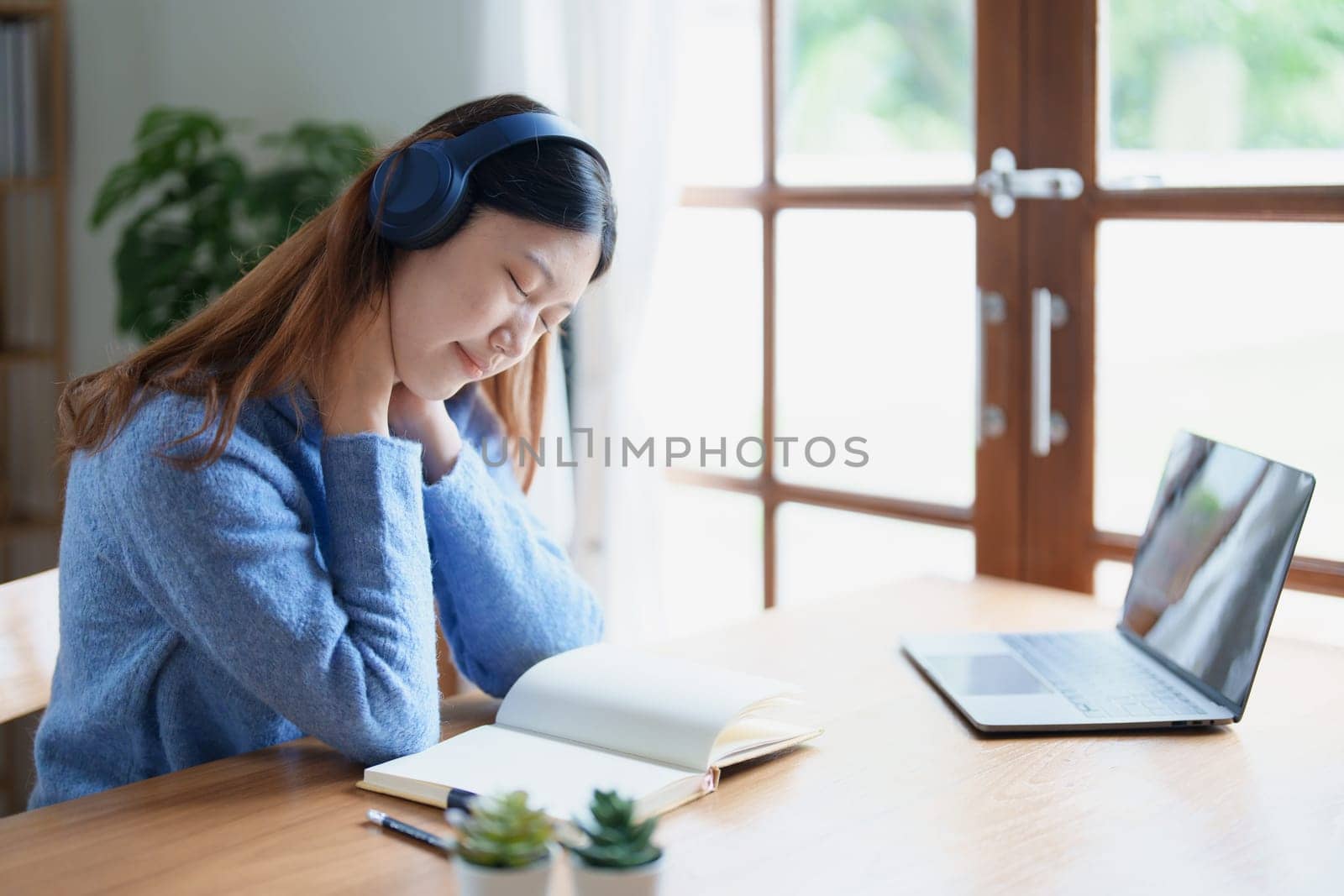 Portrait of young woman showing fatigue from studying online at home.