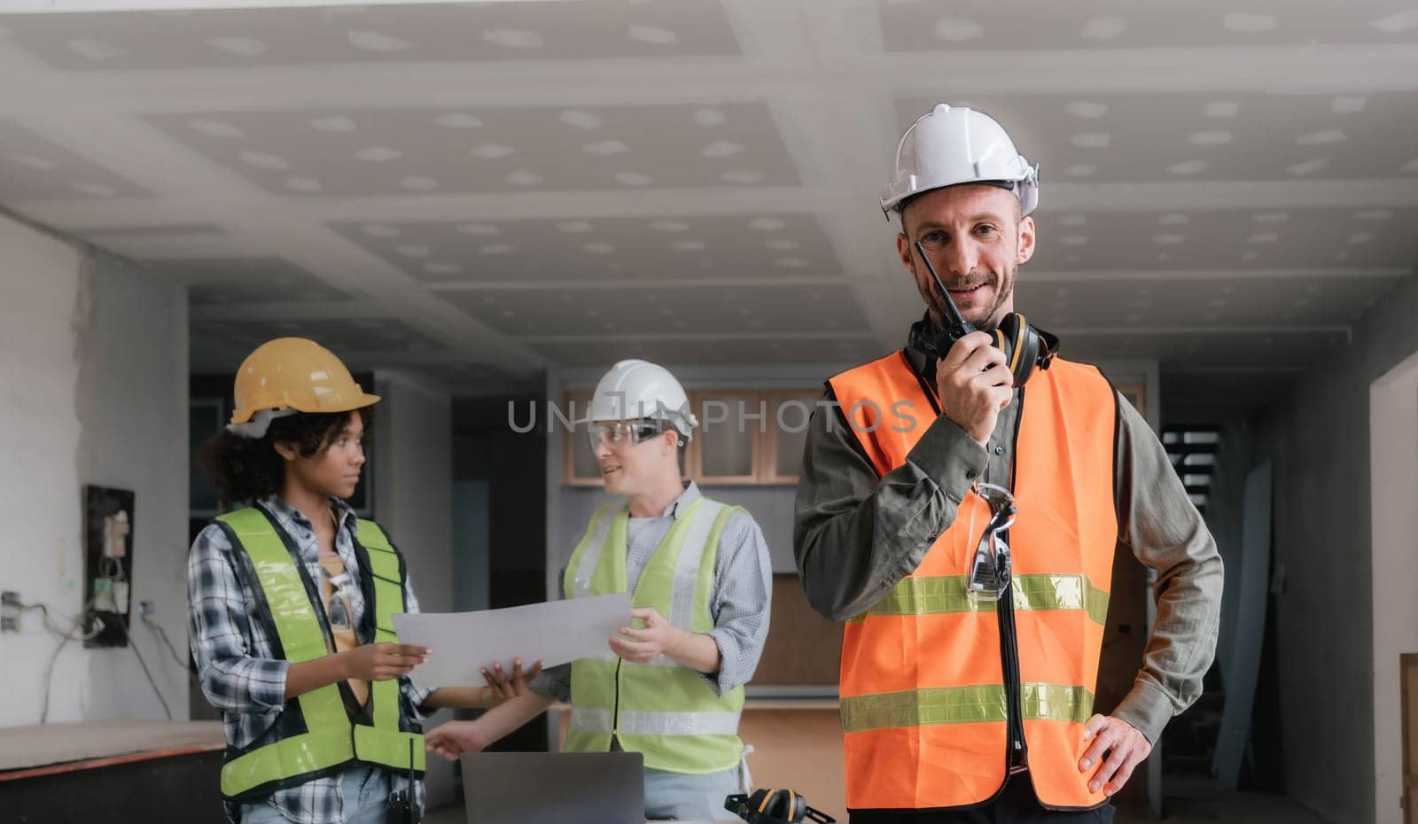 Leadership Concept by male Engineers : Portrait of a happy male engineer in front of a group of male construction workers : Effective teamwork..