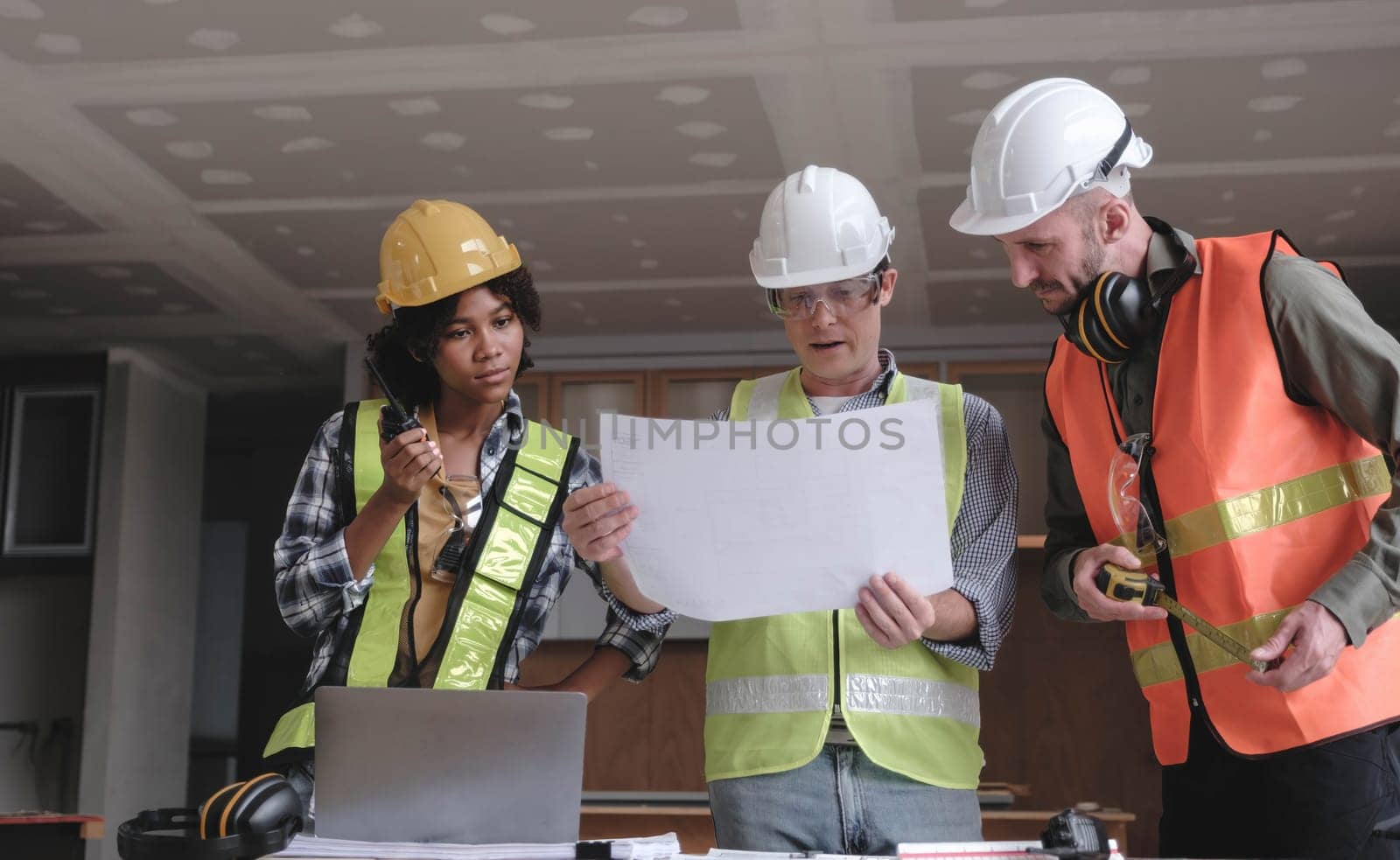 Civil engineer teams meeting working together wear worker helmets hardhat on construction site in modern city. Foreman industry project manager engineer teamwork. Asian industry professional team...