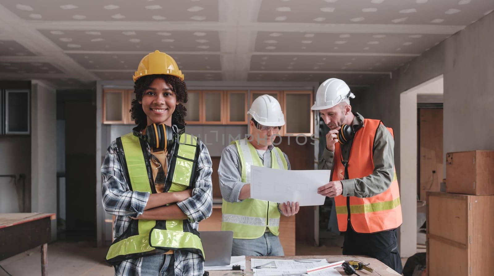 Leadership Concept by Female Engineers : Portrait of a happy female engineer in front of a group of male construction workers : Effective teamwork..