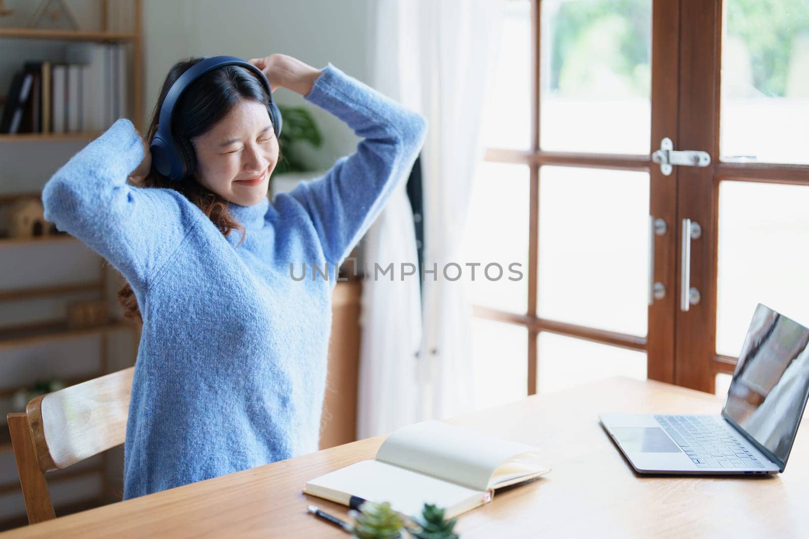 Portrait of young woman showing fatigue from studying online at home by Manastrong