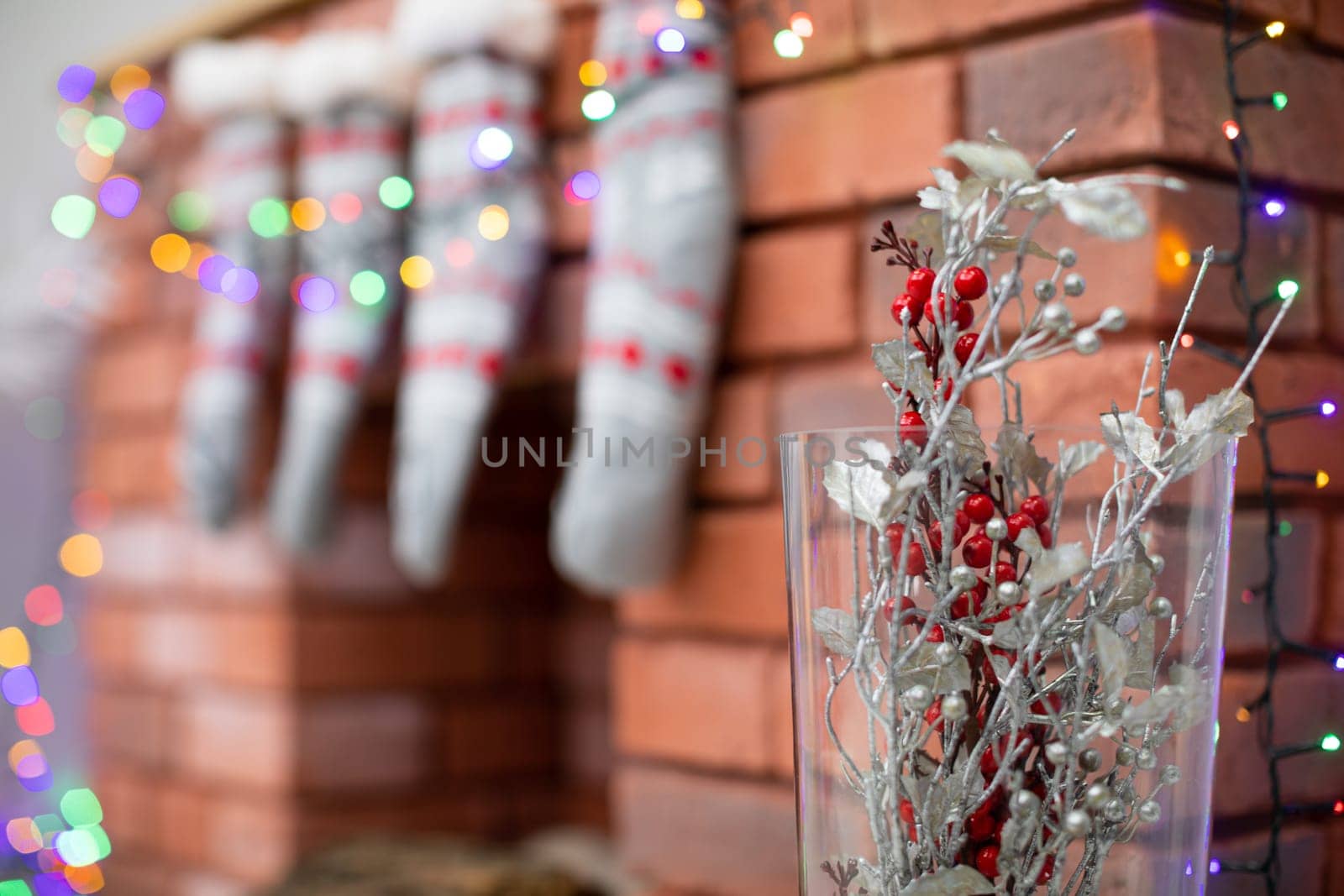 Glass vase with knobs on the background of a brick fireplace. Brick fireplace and glass vase with decorations.