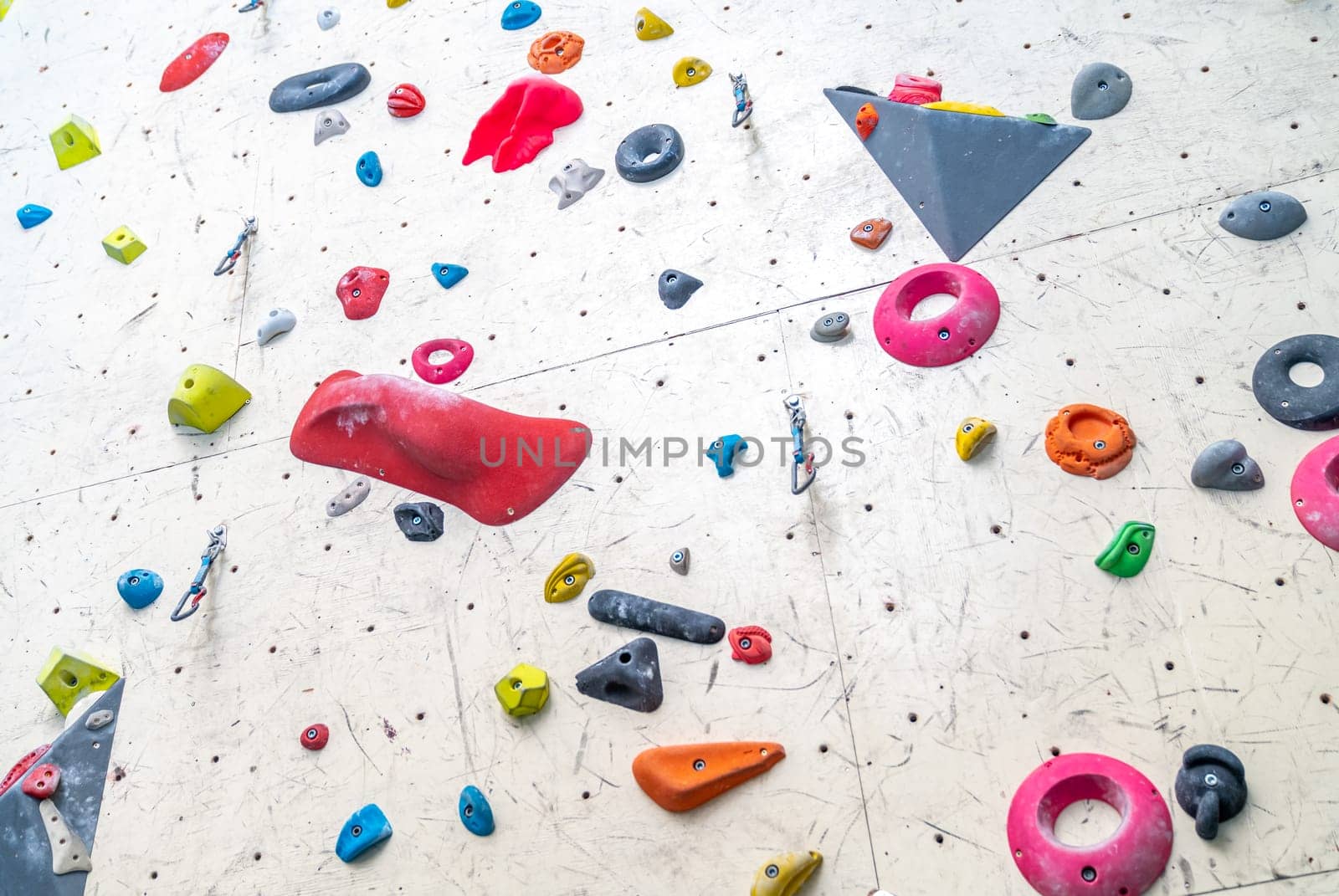 artificial climbing wall with grips and carabiners in the interior. High quality photo