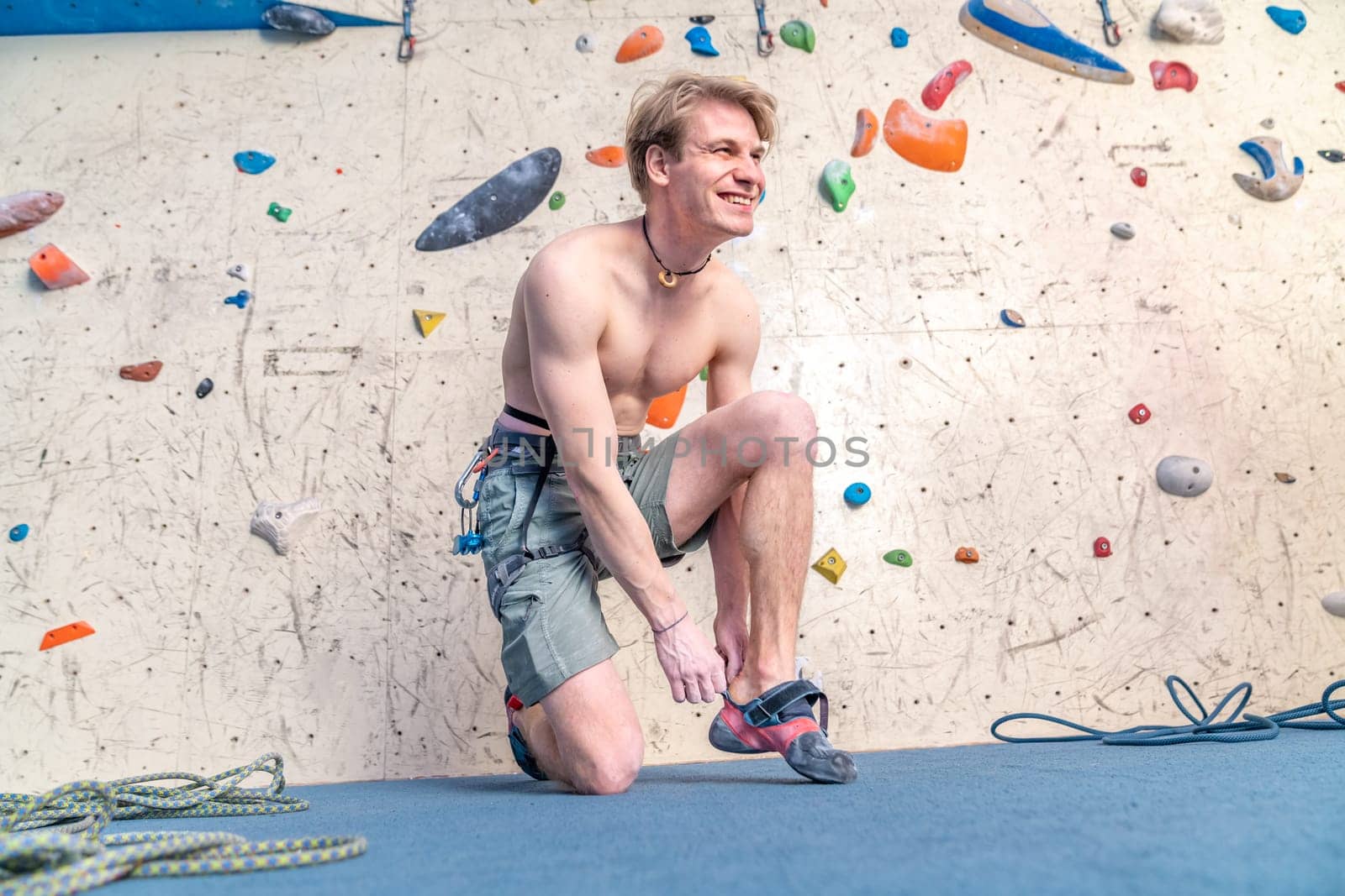 putting on climbing shoes next to the climbing wall. High quality photo