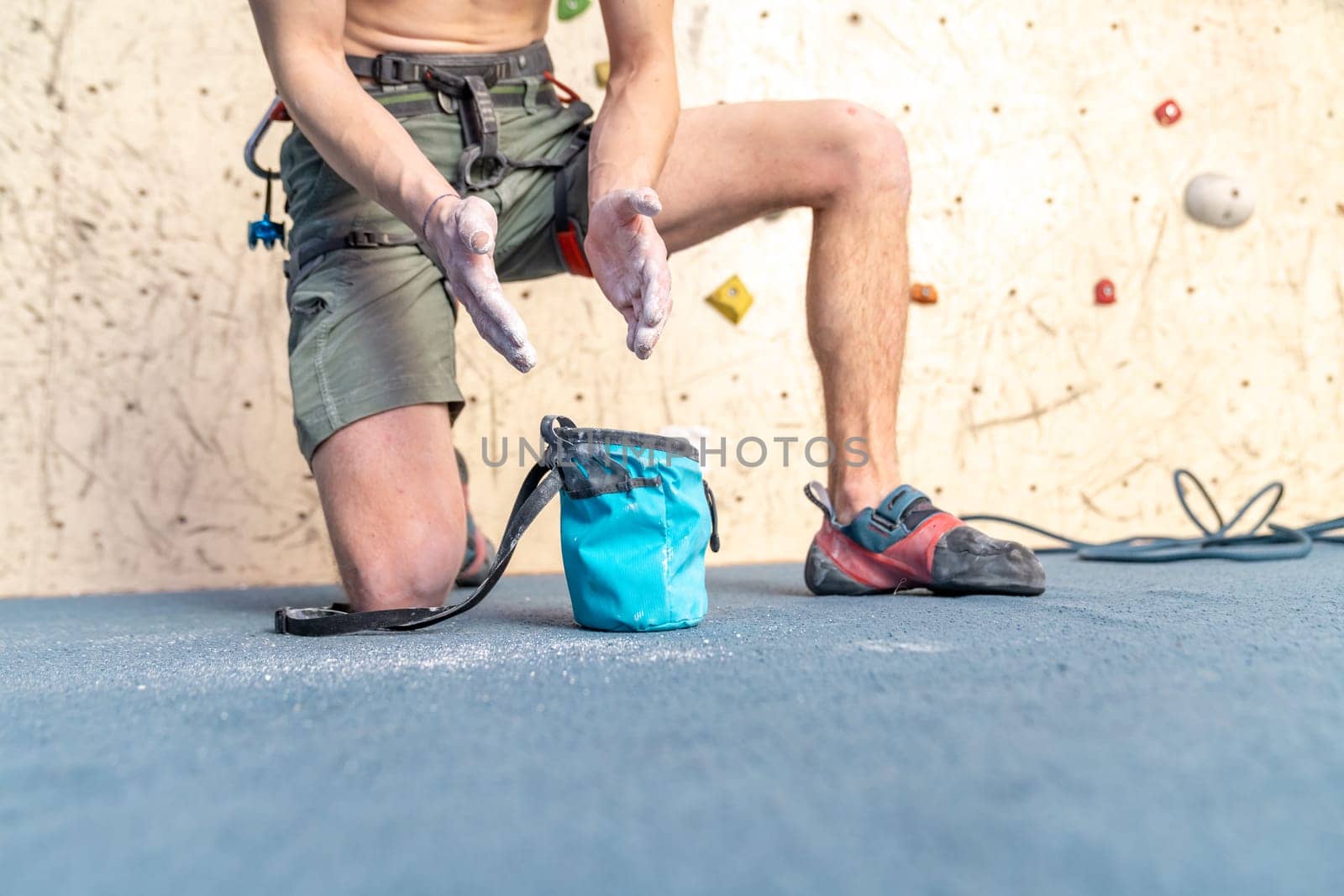 applying magnesium to the hands from the bag before climbing the climbing wall. High quality photo