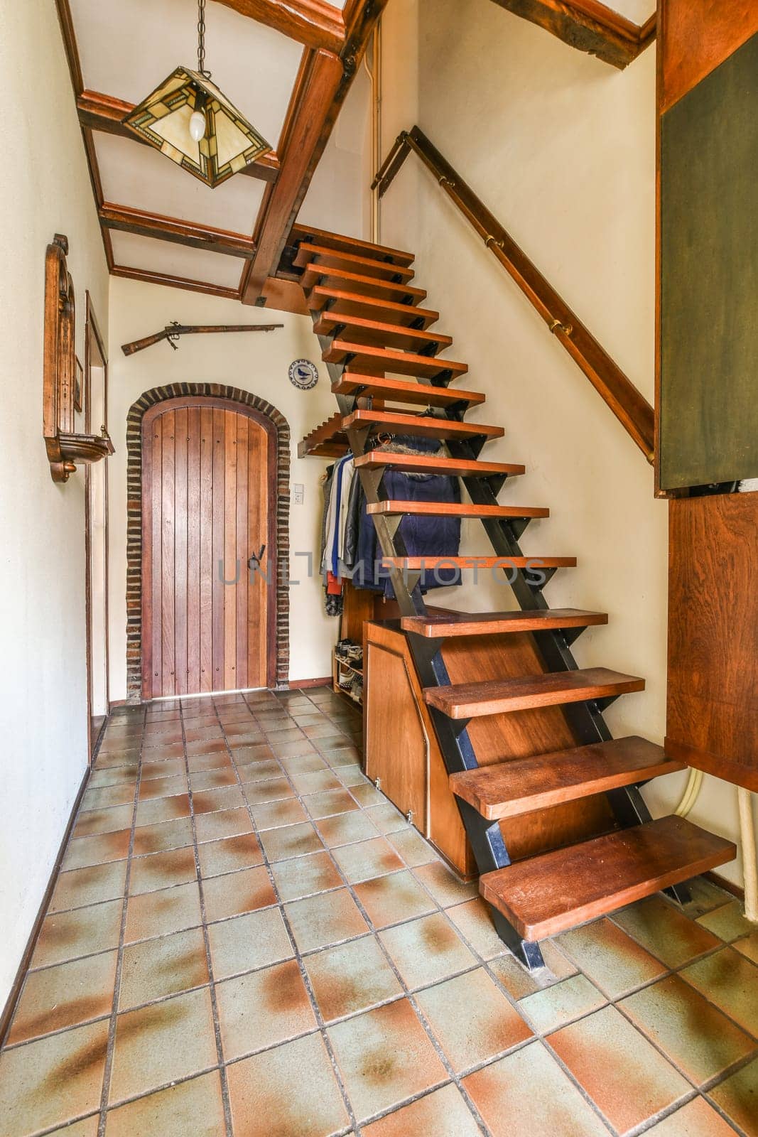 a staircase in a house with a wooden door by casamedia