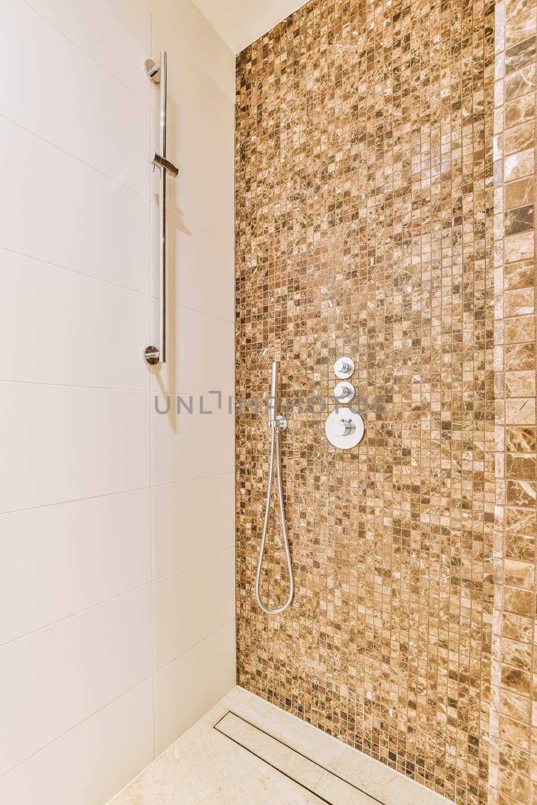 a bathroom with a shower and a tiled wall by casamedia