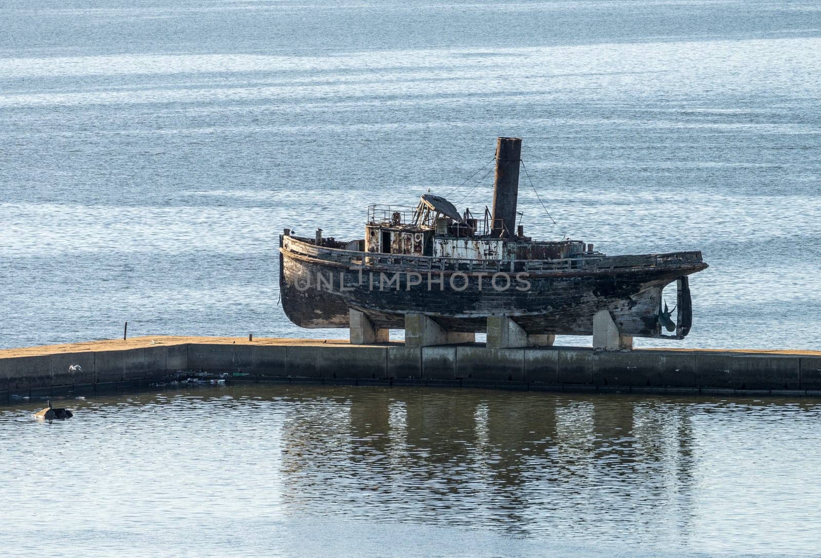 Abandoned wooden steam ship on stands on pier in Montevideo harbor in Uruguay