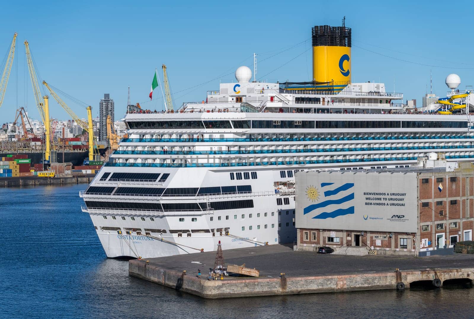 Montevideo, Uruguay - 5 February 2023: Detail of Costa Fortuna cruise ship docked in the harbor by Welcome to Uruguay sign