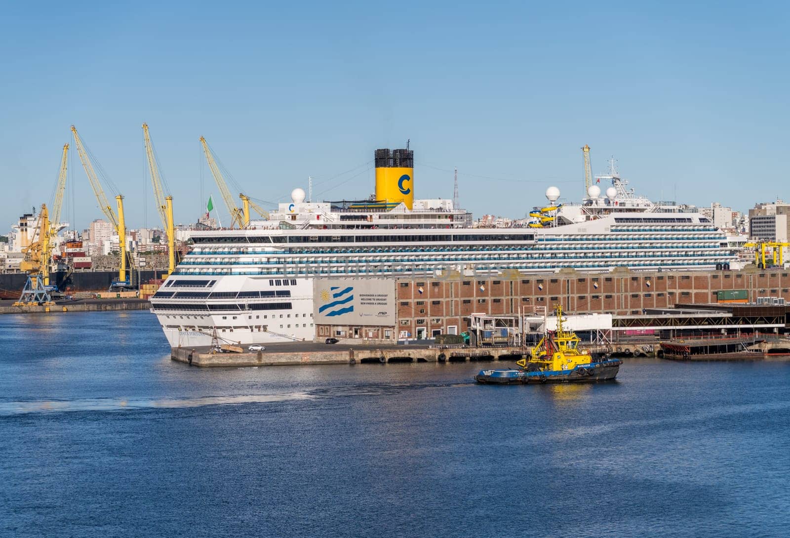 Montevideo, Uruguay - 5 February 2023: Detail of Costa Fortuna cruise ship docked in the harbor by Welcome to Uruguay sign