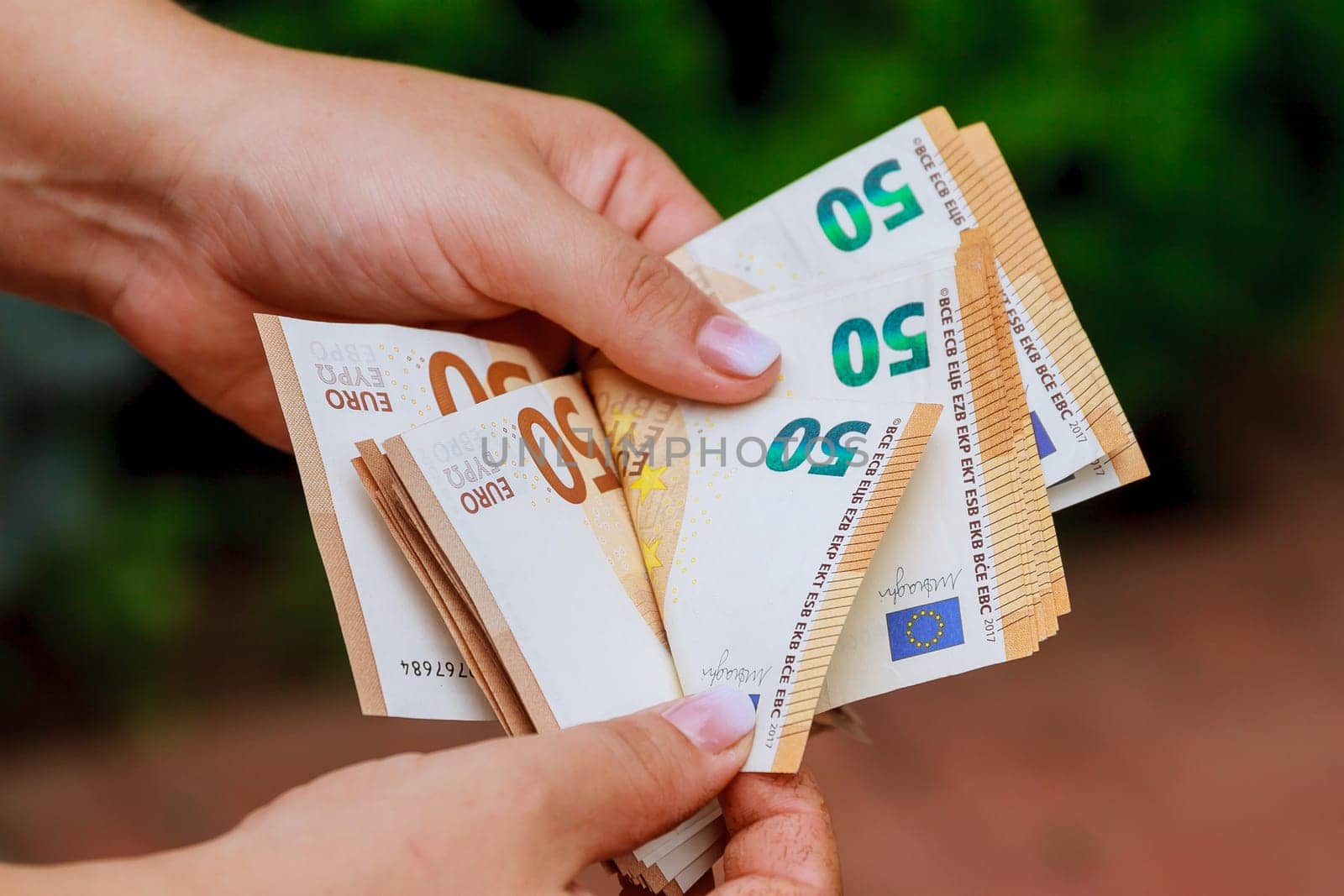 Recalculation of euros by the hands of a banker, European currency.